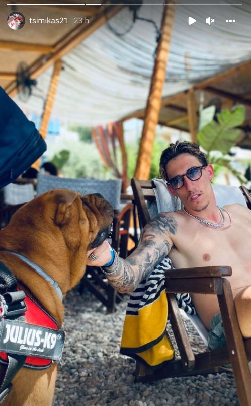 Tsimikas seen relaxing without his cornrows but with his dog
