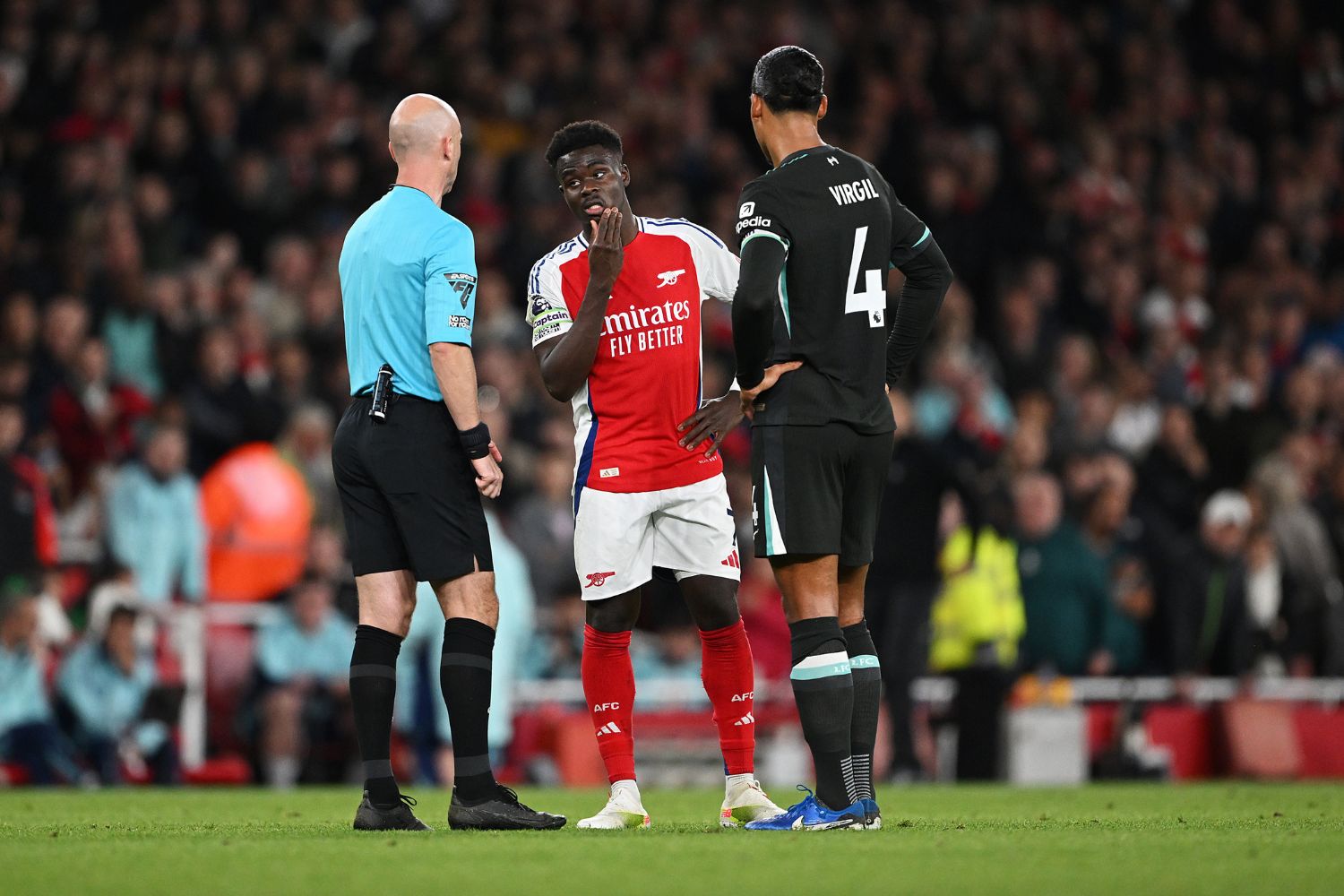 Virigl van Dijk alongside one of the falsely rumoured to be injured Arsenal players, Bukayo Saka