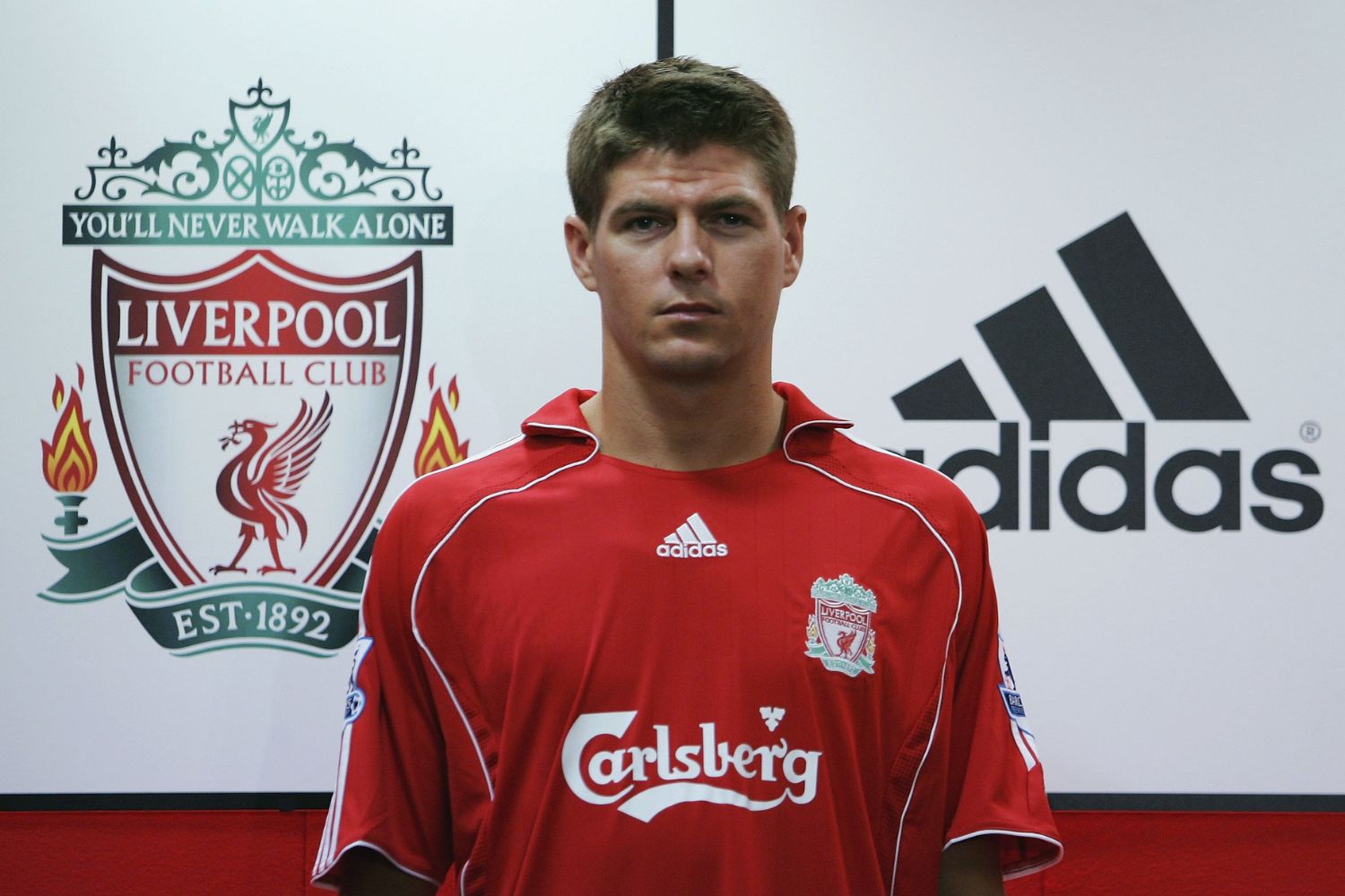 Steven Gerrard poses in front of Liverpool and Adidas logos