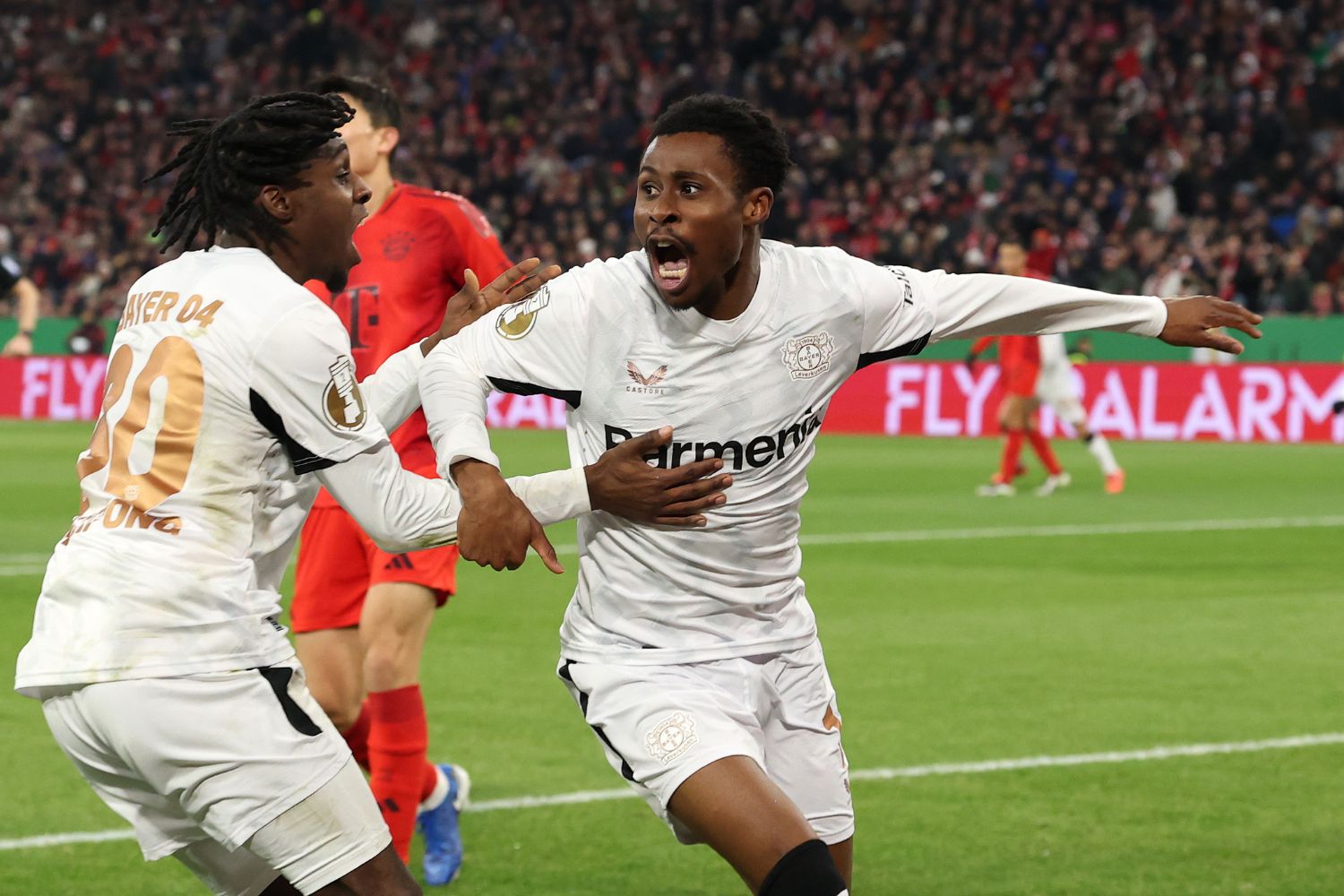 Nathan Tella of Bayer 04 Leverkusen celebrates scoring his team's first goal with teammate Jeremie Frimpong