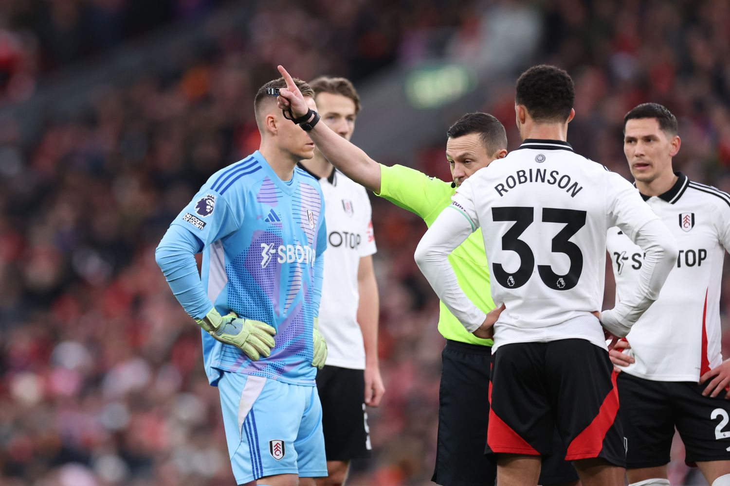 Referee Tony Harrington with Bernd Leno at Anfield