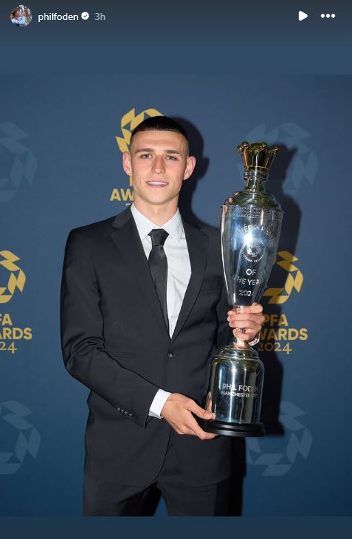 Phil Foden poses with the footballer of the year trophy