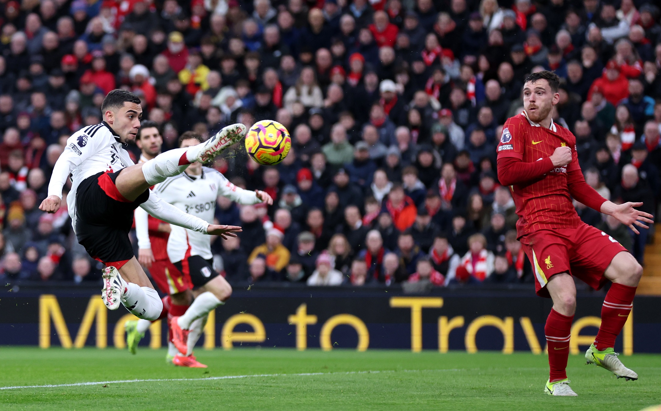 Andy Robertson tries to block Andreas Pereira shot.