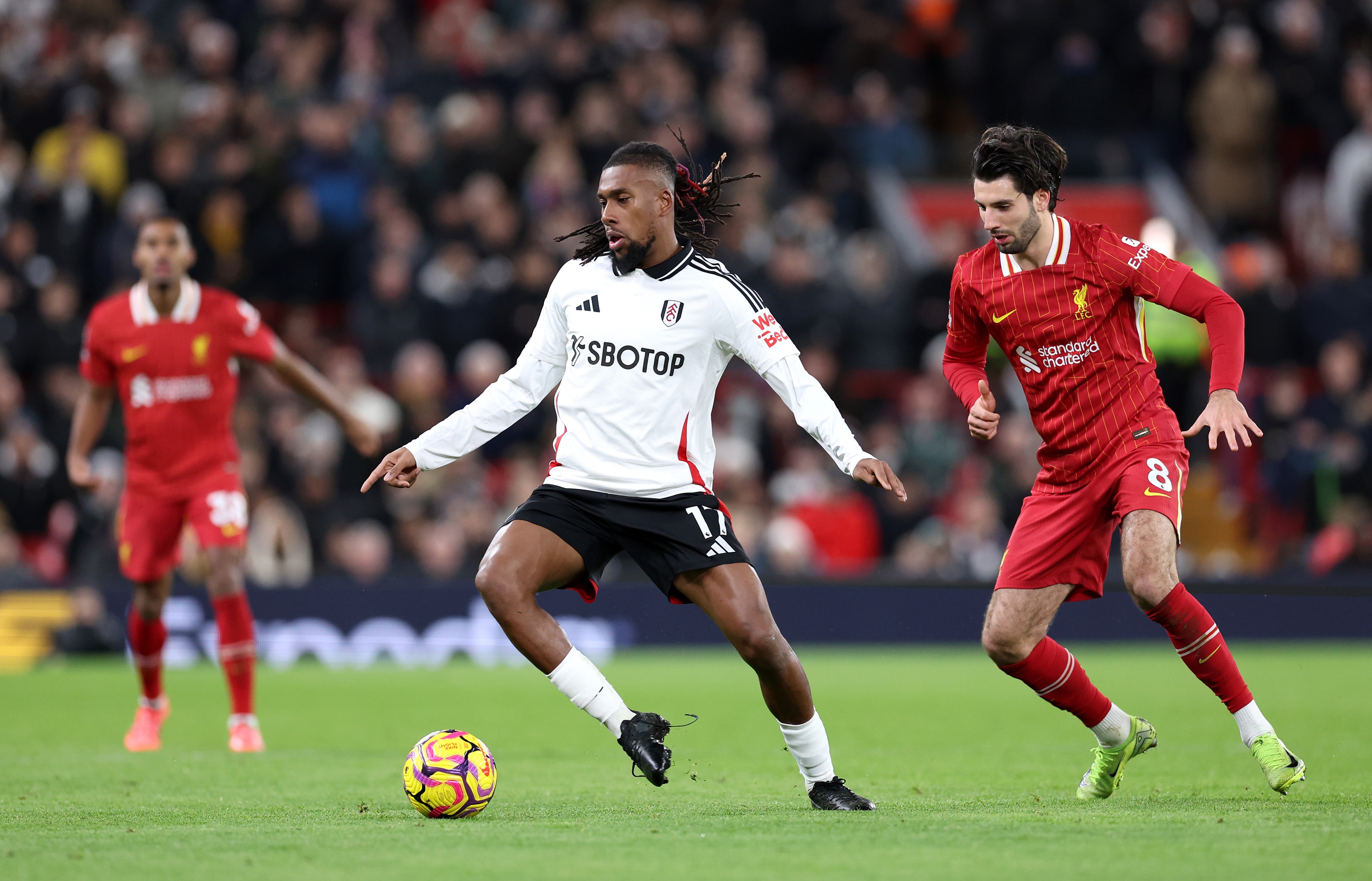 Dominik Szoboszlai presses Alex Iwobi at Anfield.
