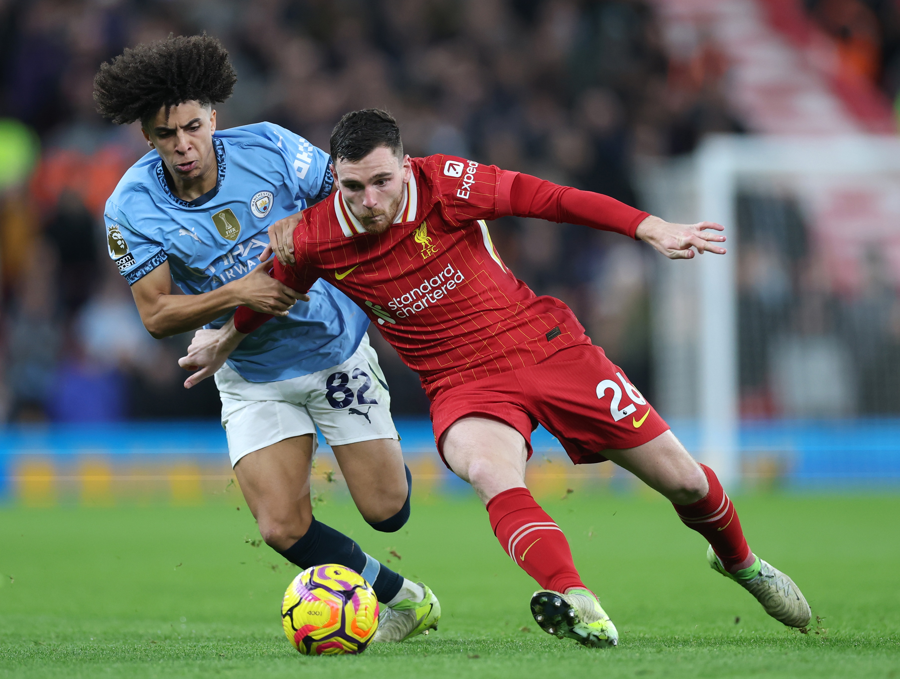 Andy Robertson and Rico Lewis compete for the ball.