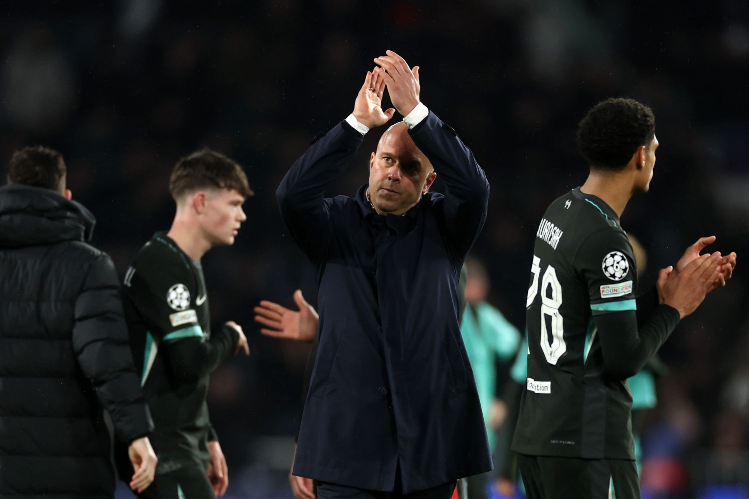 Arne Slot applauds the Liverpool fans with James McConnell behind him