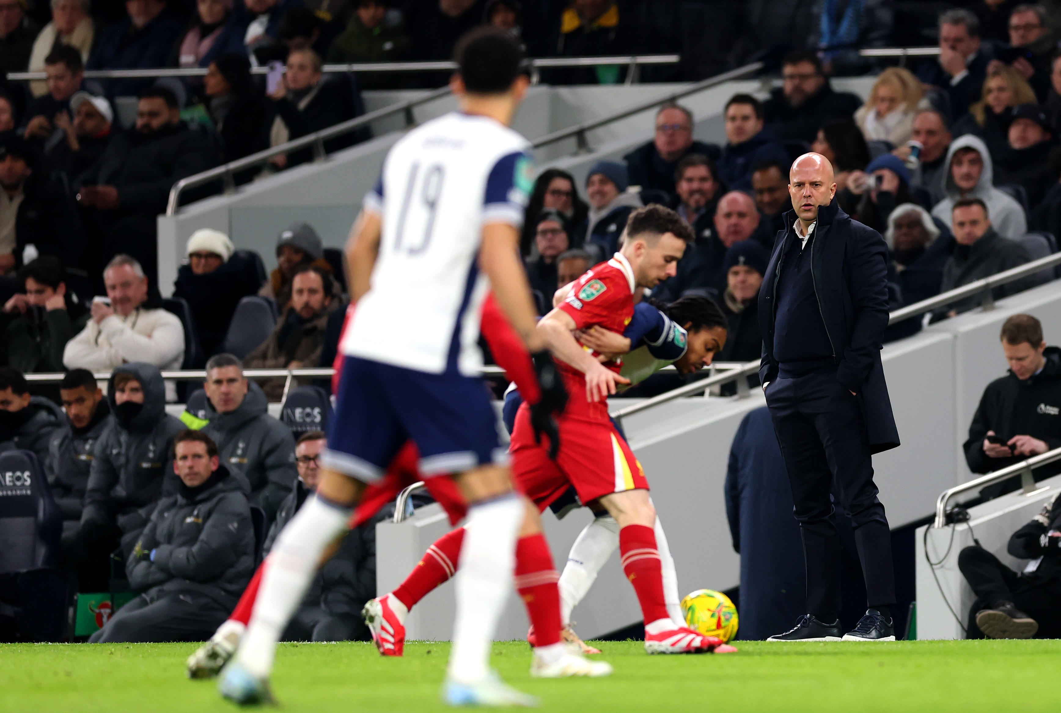 Arne Slot watches on from the technical area as Diogo Jota dribbles the ball for Liverpool.