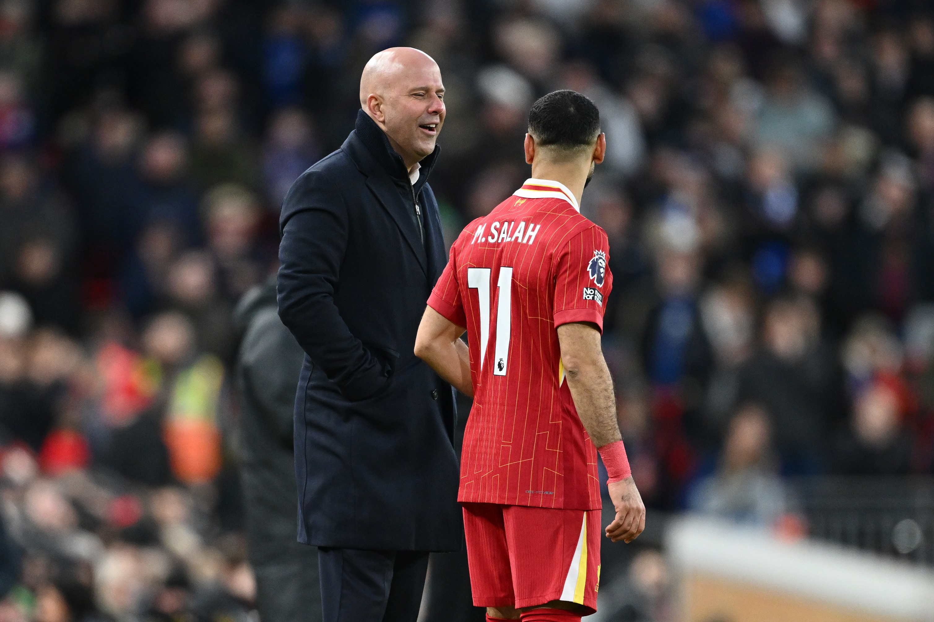 Arne Slot talks with Mo Salah at Anfield.