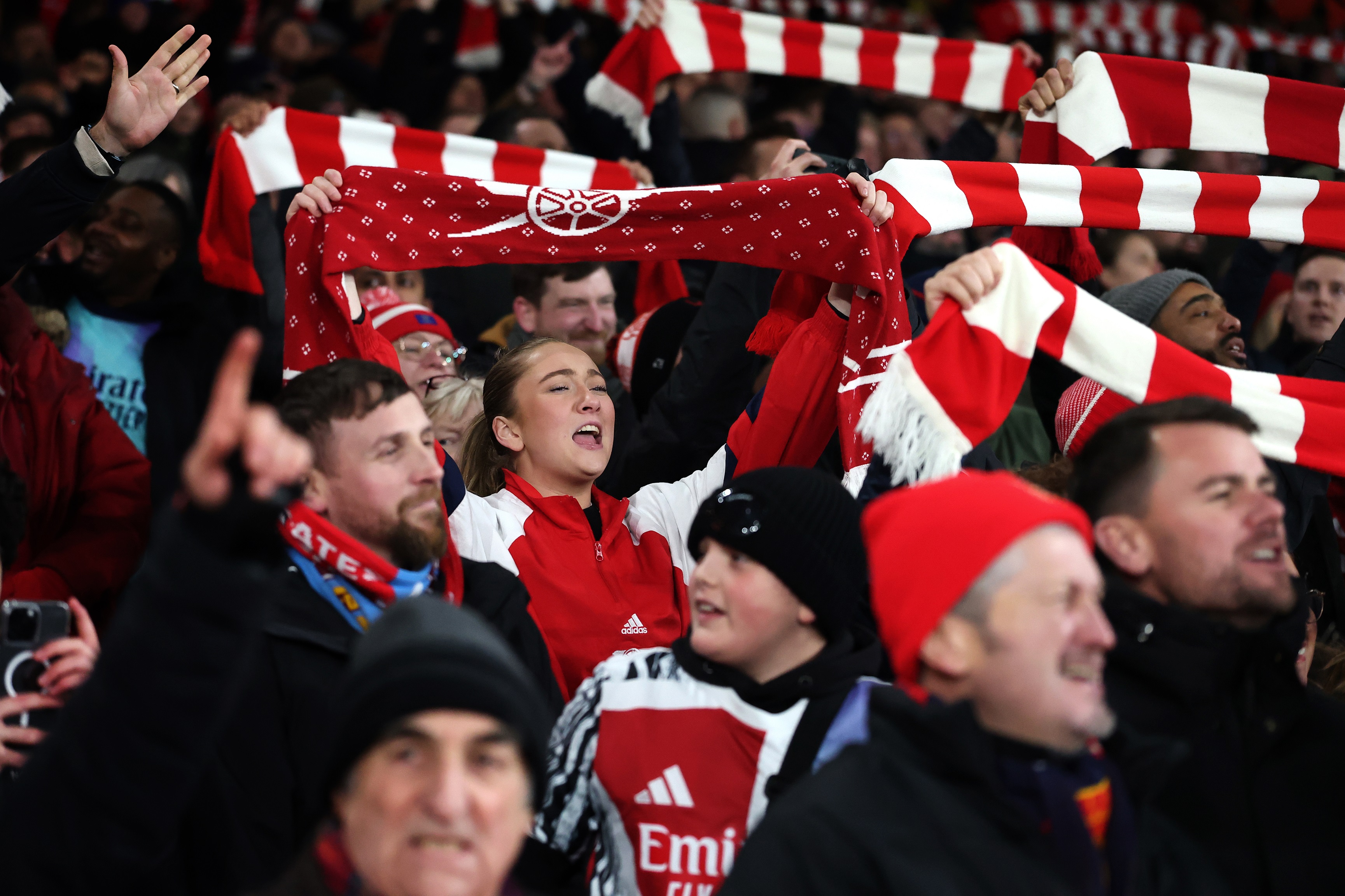 Arsenal supporters lift up their scarves at the Emirates Stadium.