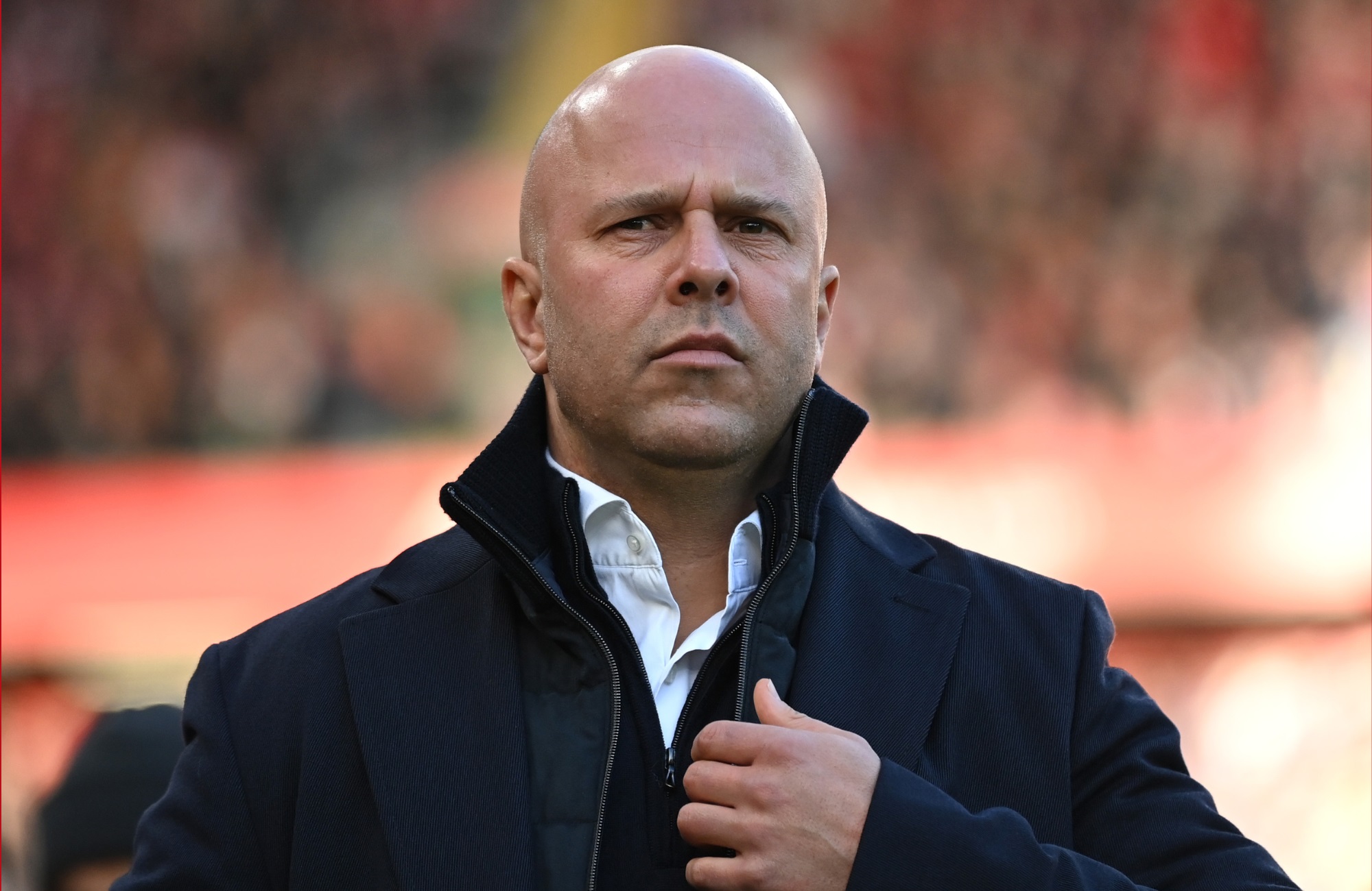 Arne Slot grabs his jacket at Anfield.