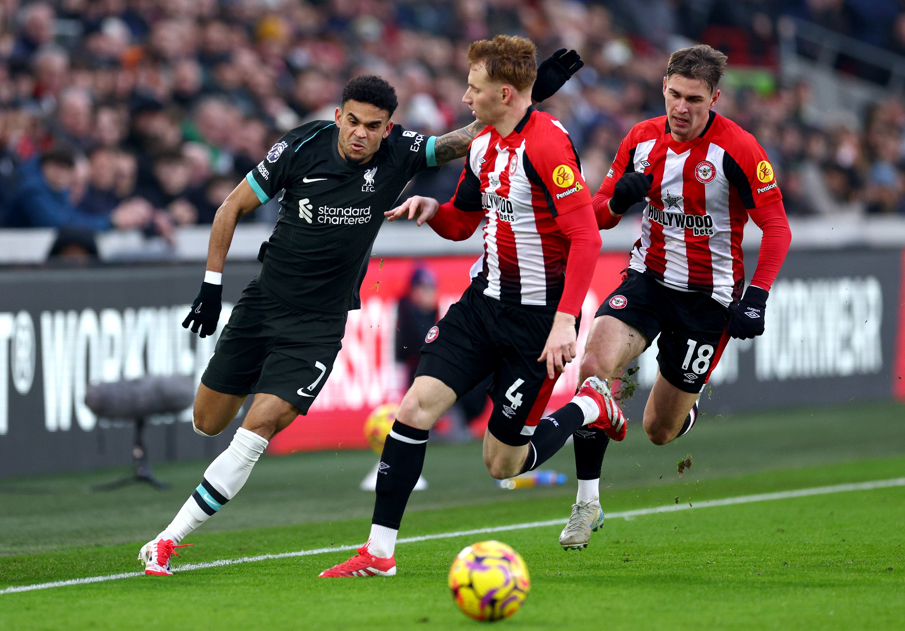 Luis Diaz dribbles past Sepp van den Berg at the Gtech Community Stadium.