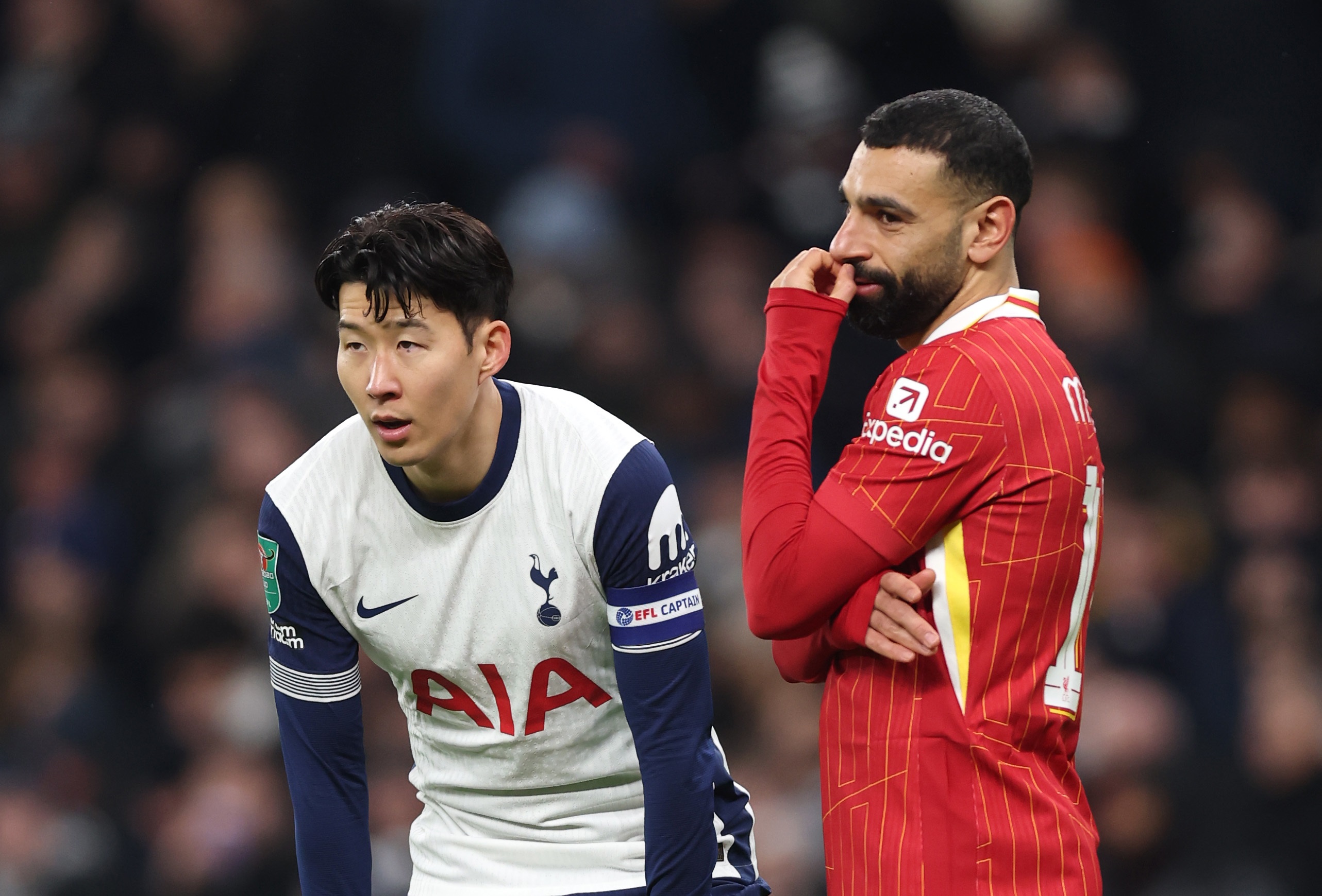 Mo Salah touches his face whilst standing next to Heung-Min Son