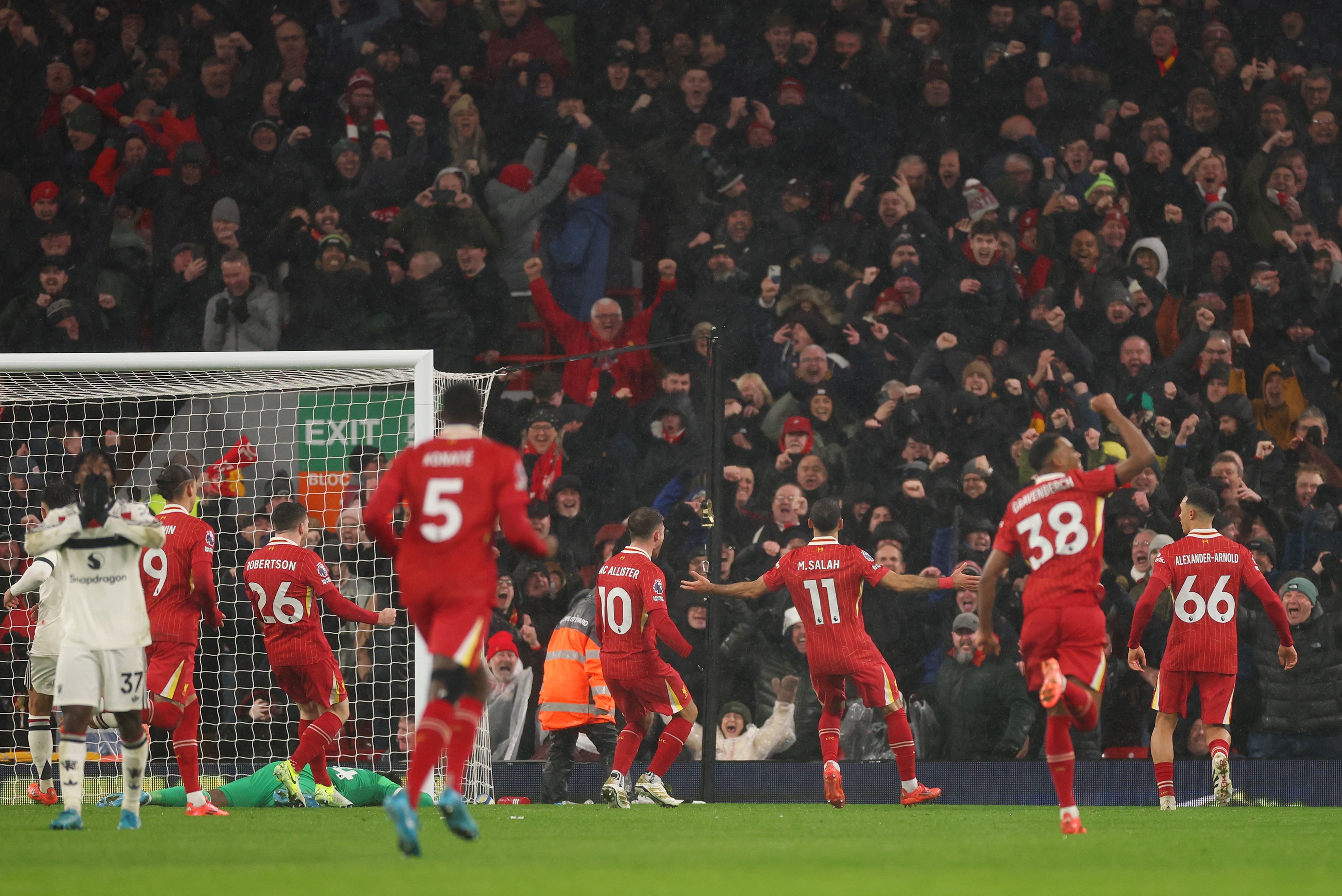 Trent Alexander-Arnold celebrates after Mo Salah scores a penalty at Anfield.