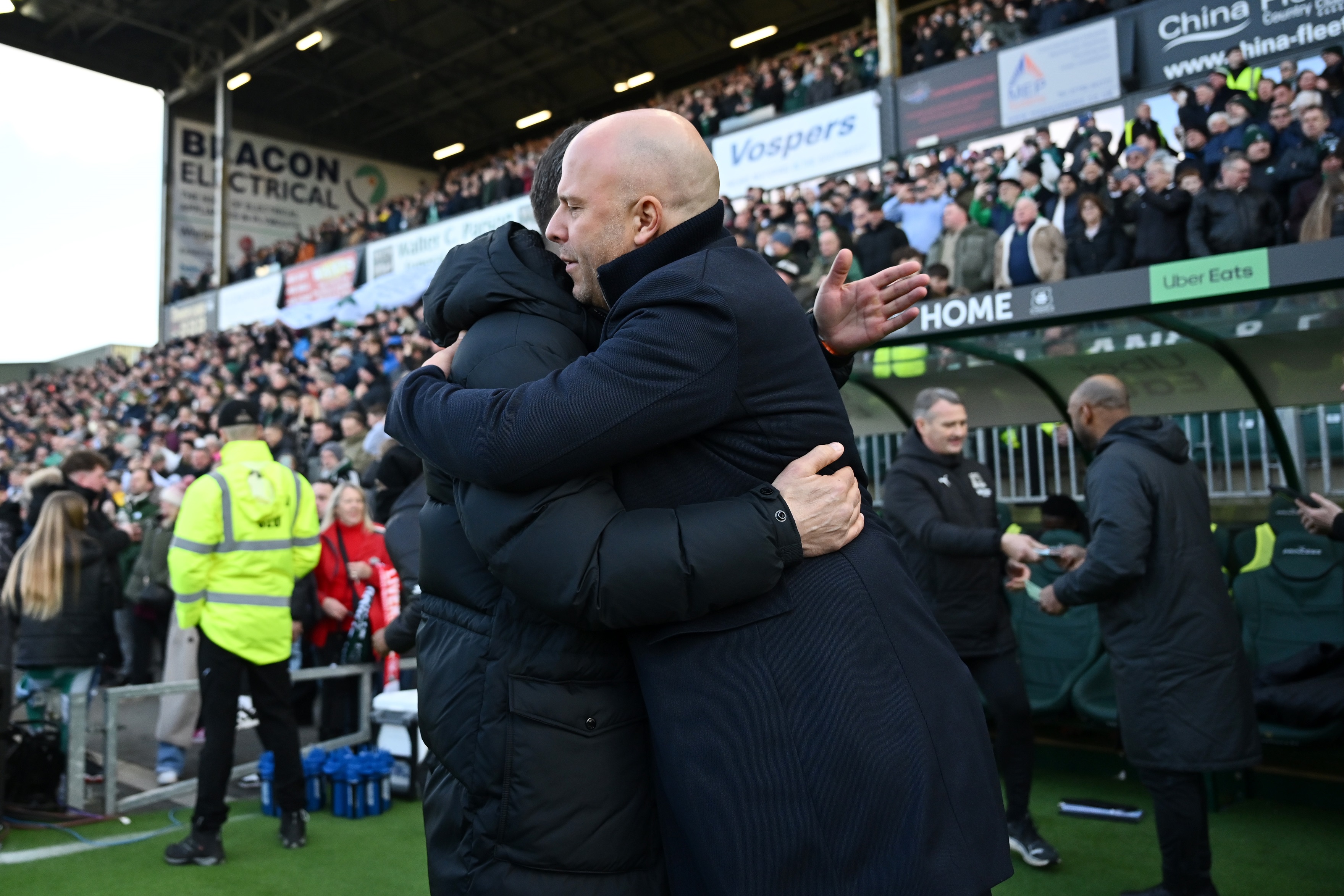 Arne Slot hugs Plymouth boss Miron Muslic.