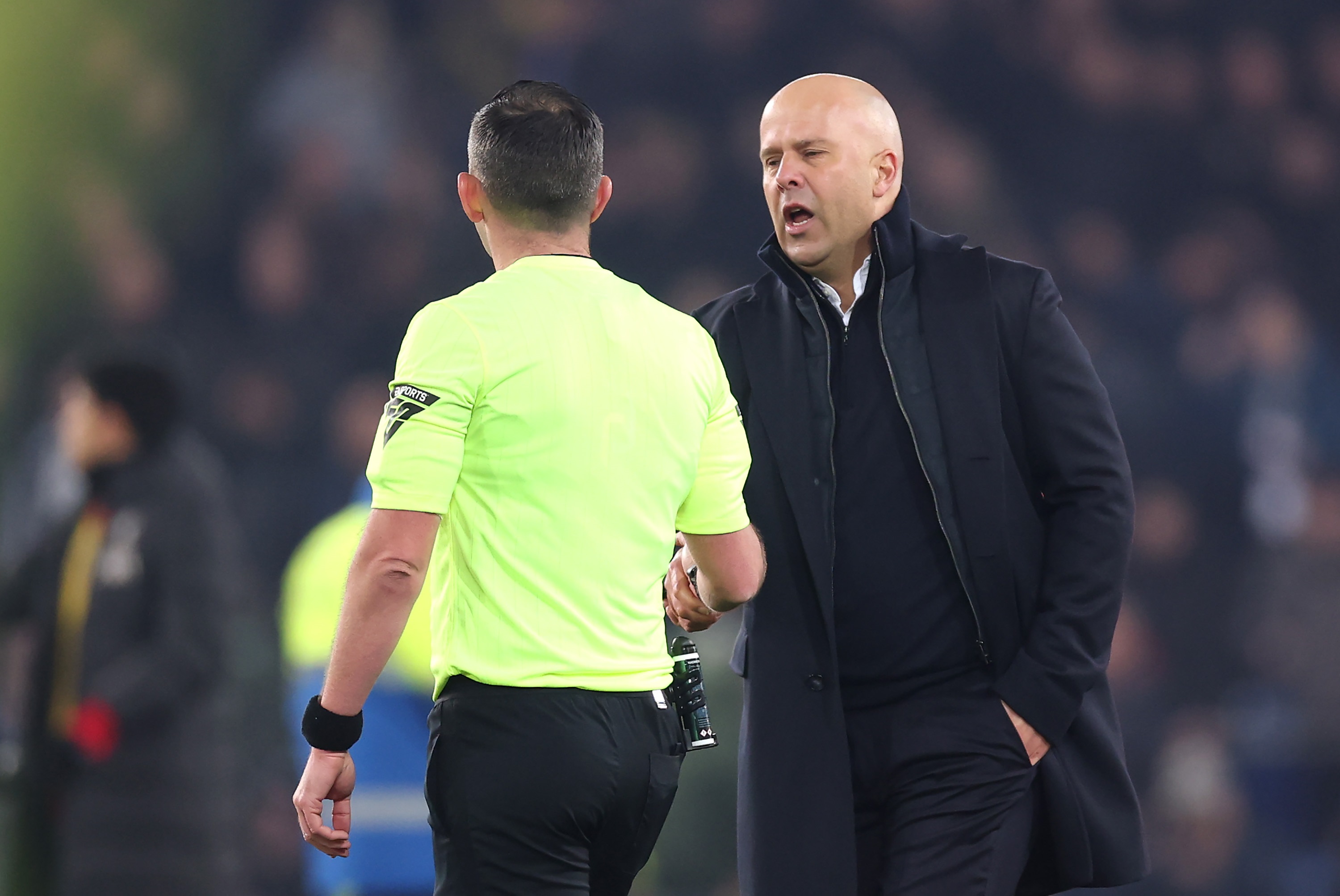 Arne Slot speaks with Premier League referee Michael Oliver.