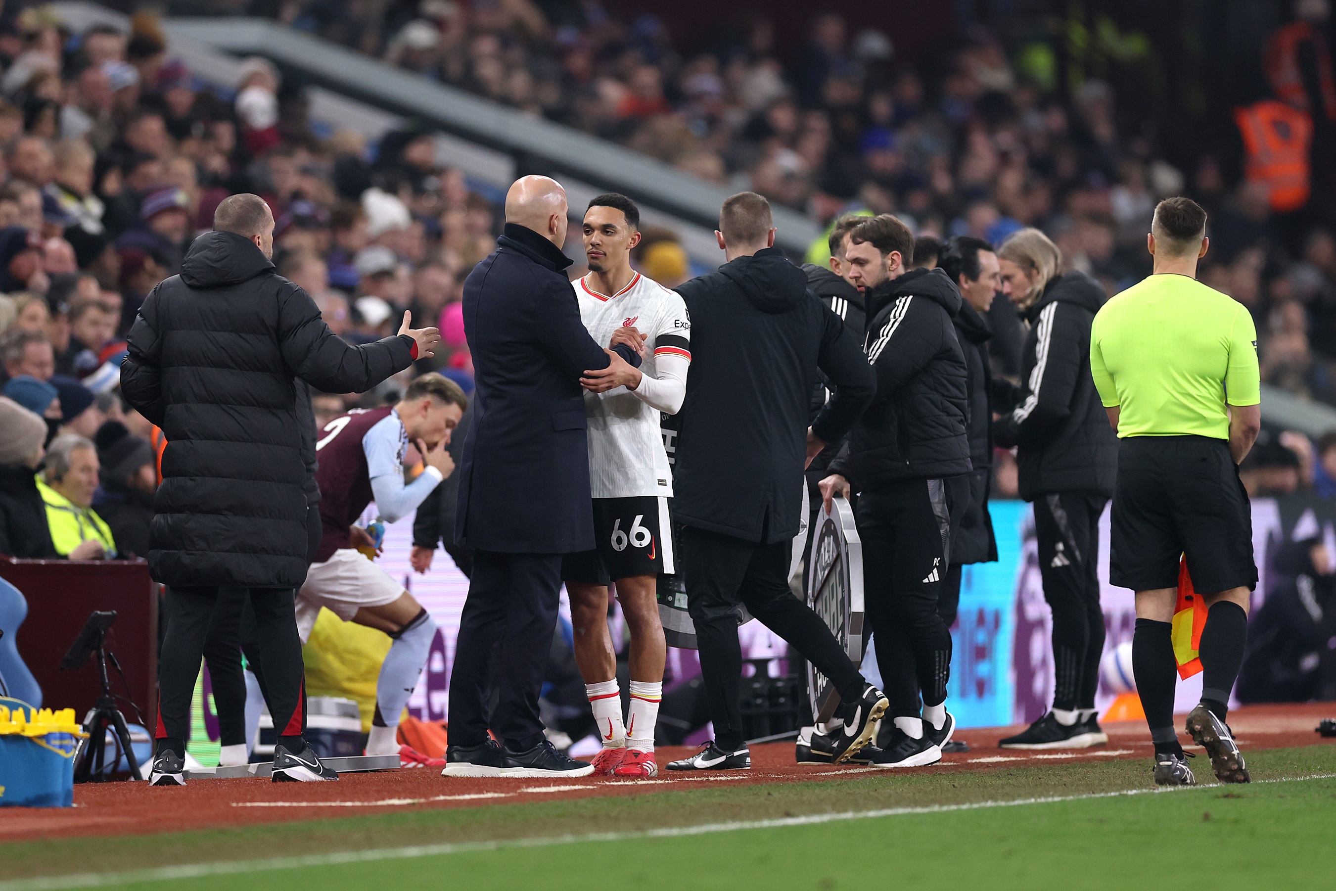 Trent Alexander-Arnold shakes hands with Arne Slot on the touchline.