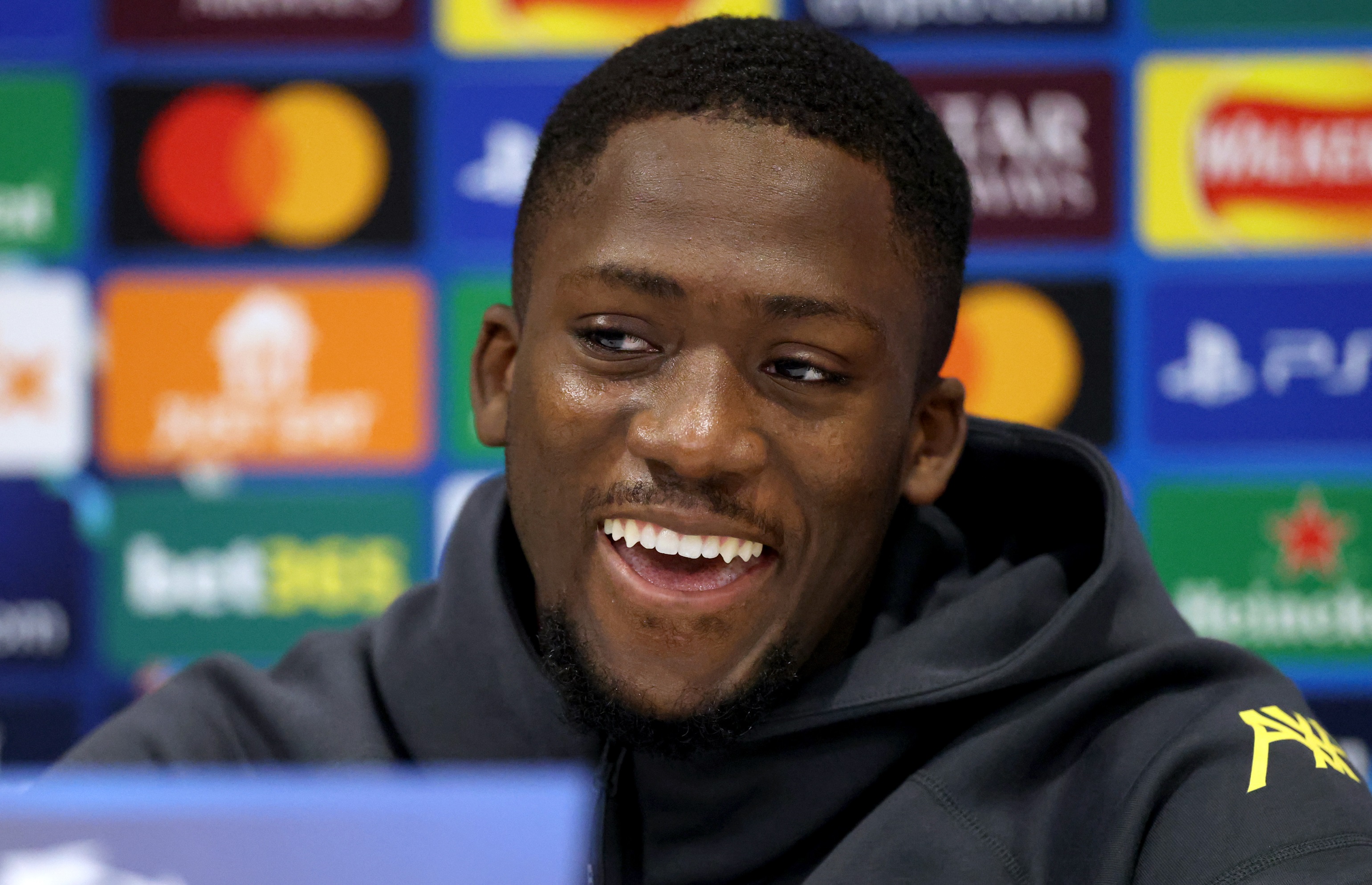 Ibrahima Konate laughs during Liverpool press conference.