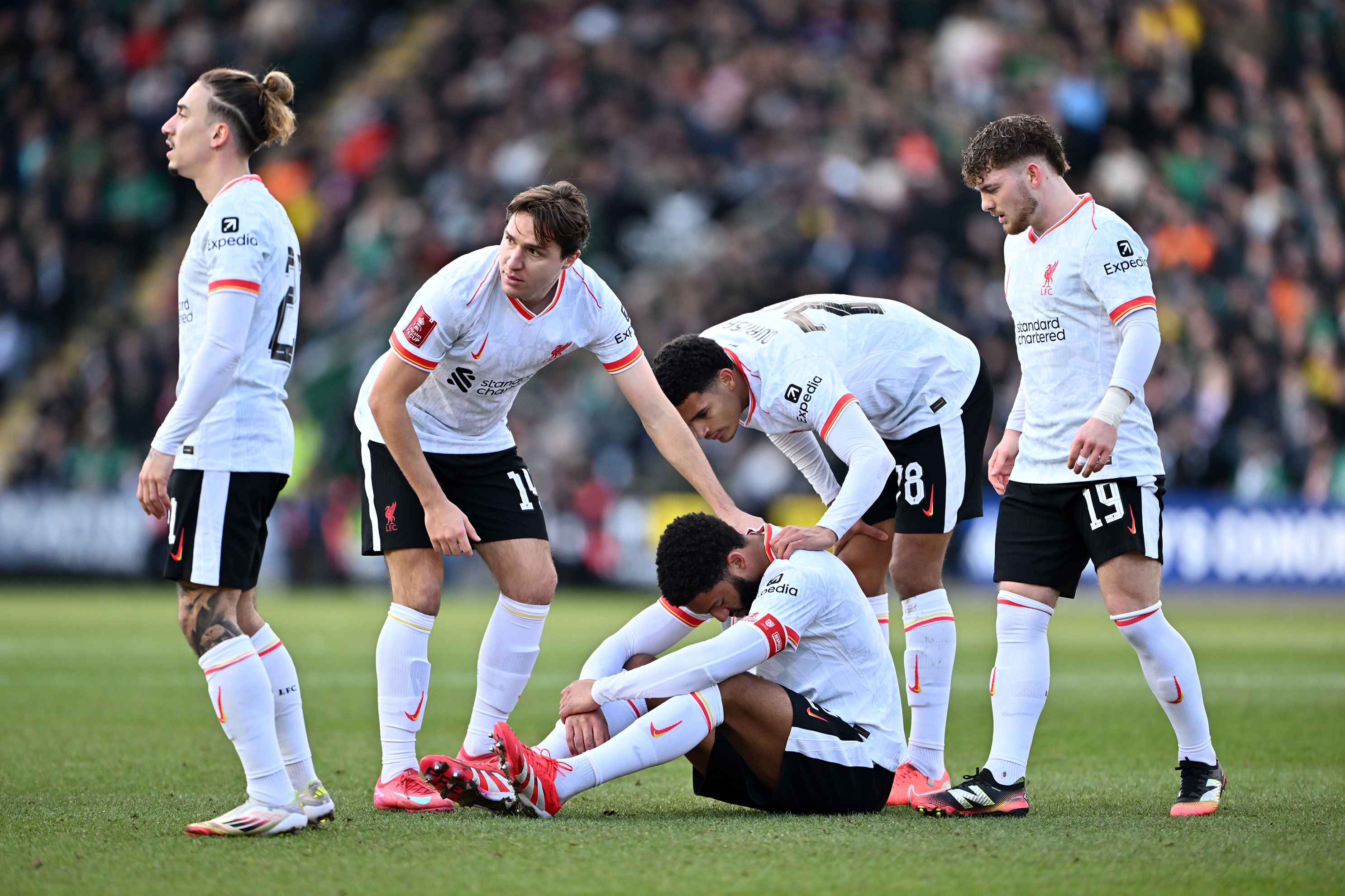 Liverpool players comfort Joe Gomez after injury blow.