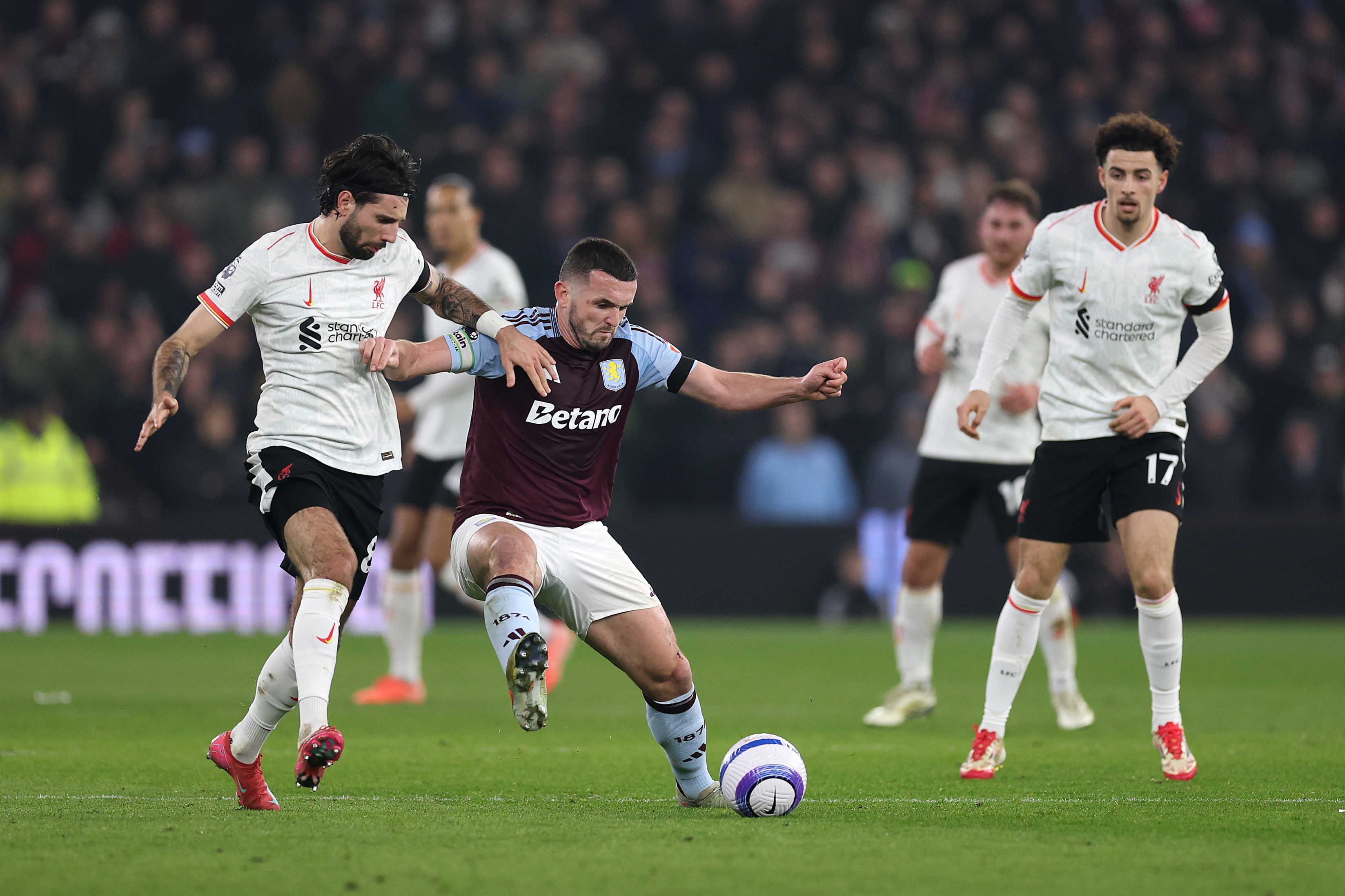 John McGinn dribbles away from Liverpool midfielder Dominik Szoboszlai.