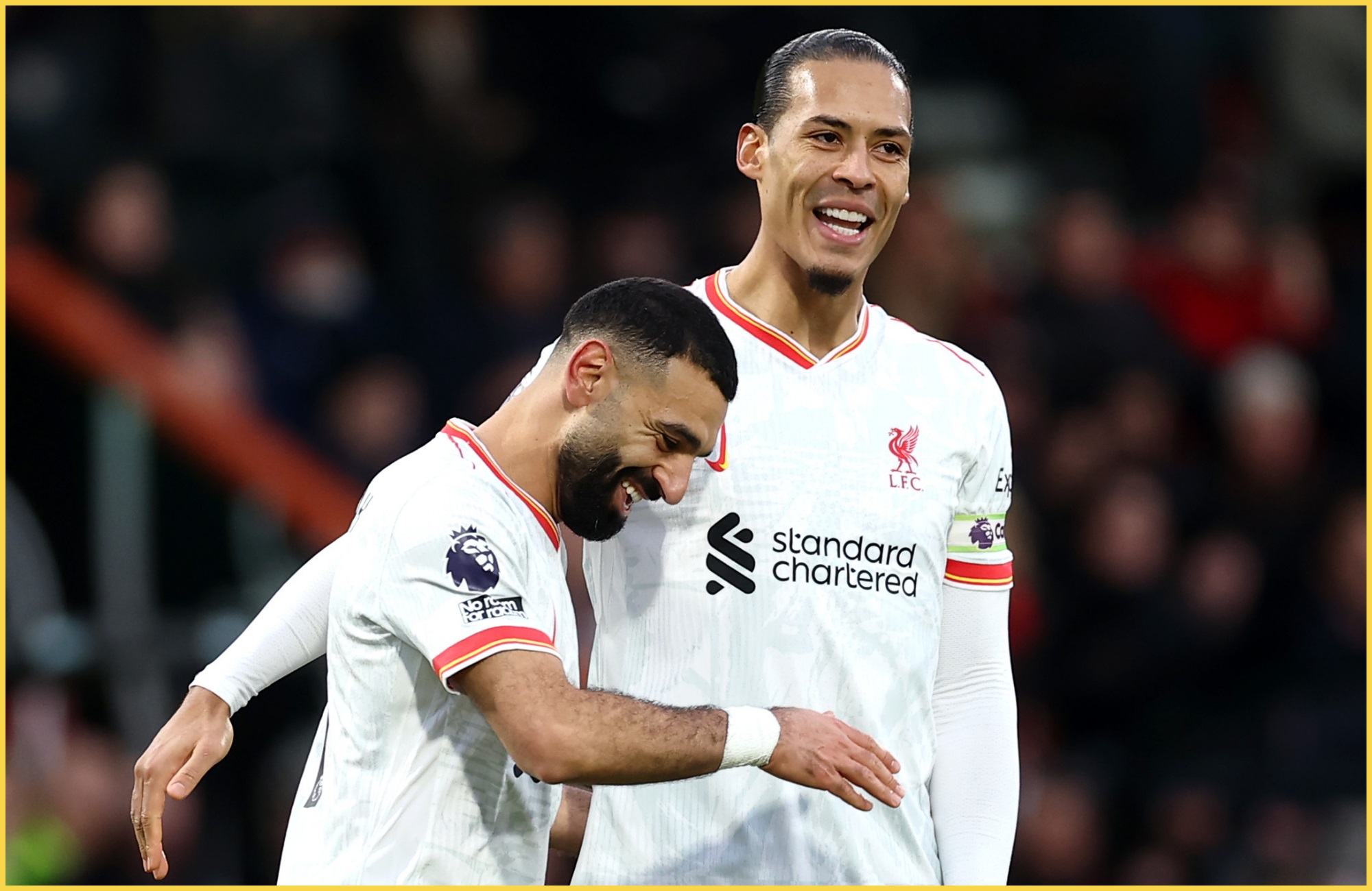 Mo Salah and Virgil van Dijk laugh with each other on the pitch.
