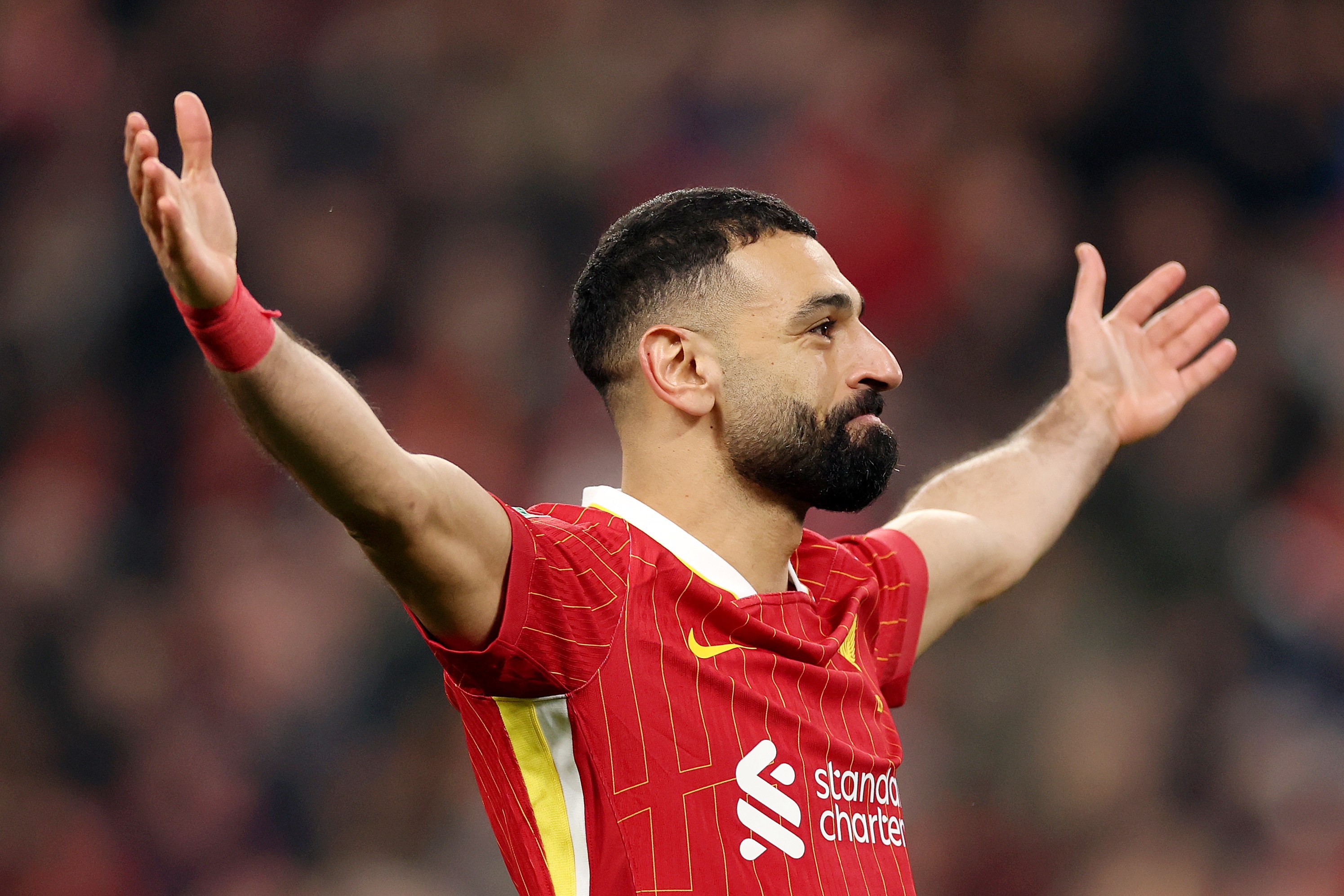 Mo Salah holds his arms up after scoring Liverpool penalty.