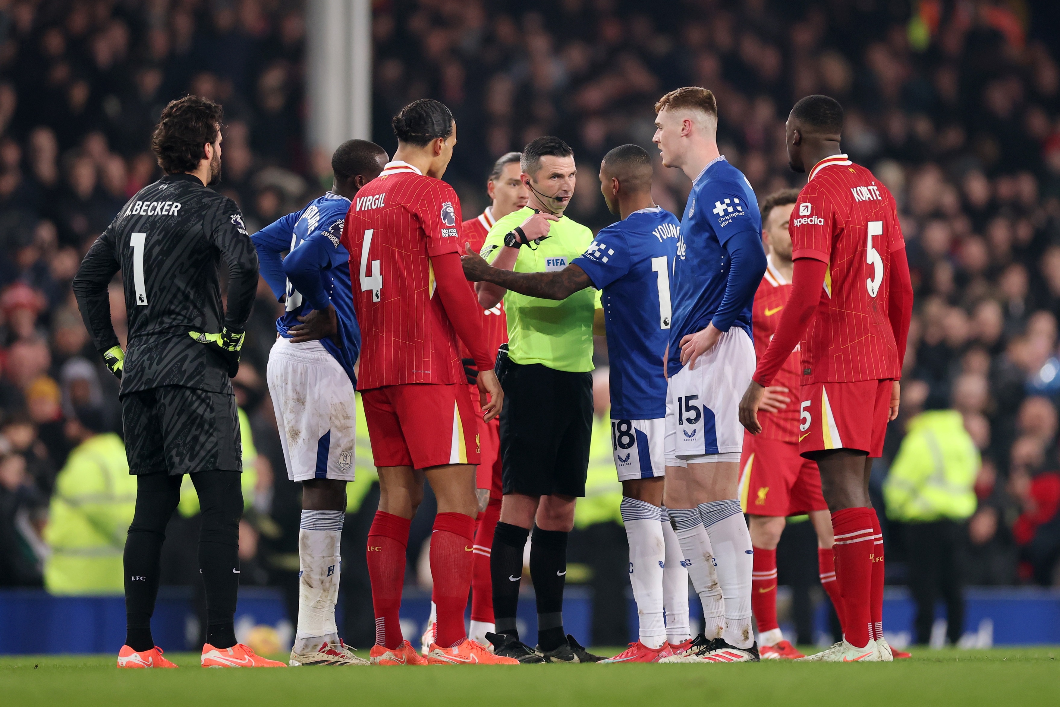 Michael Oliver speaks to Liverpool and Everton players.