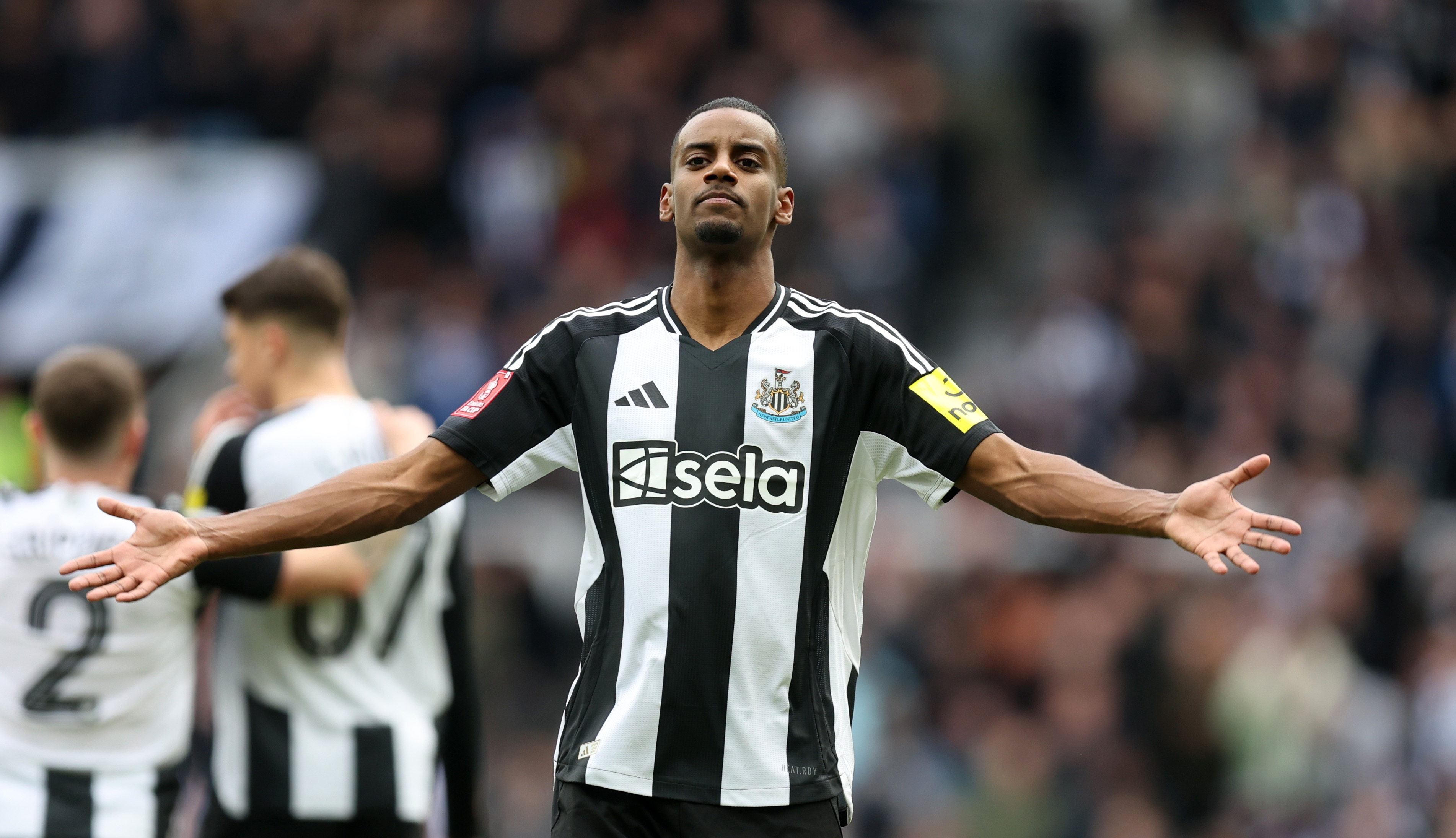 Alexander Isak holds out his arms in celebration.