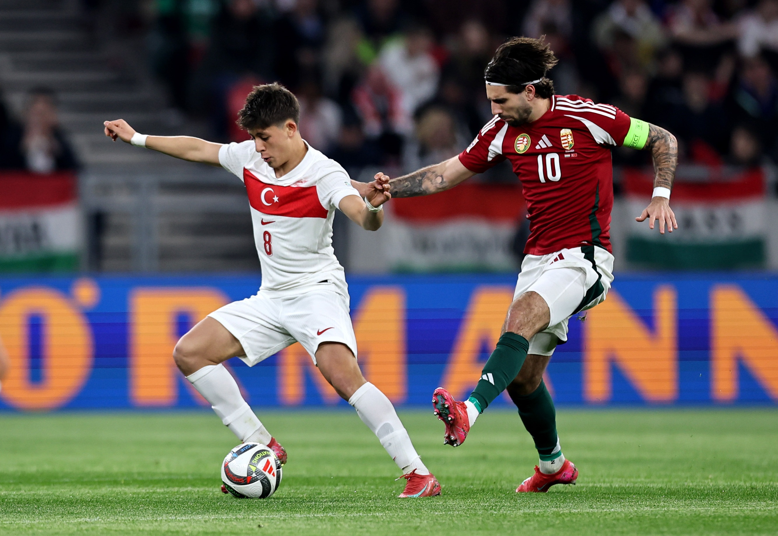 Dominik Szoboszlai lifts his boot to tackle Arda Guler during Turkey v Hungary.