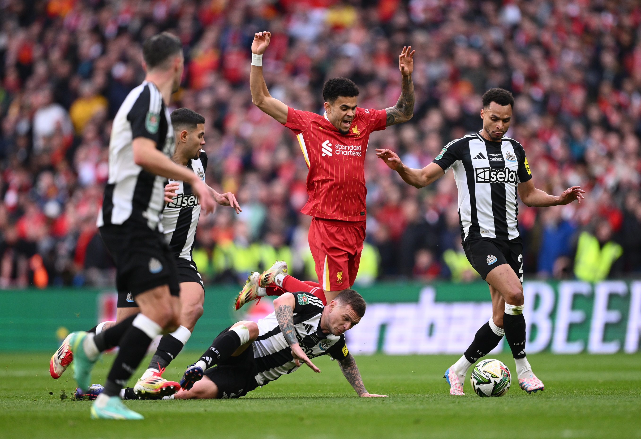 Kieran Trippier falls on the floor as Luis Diaz chases a loose ball.