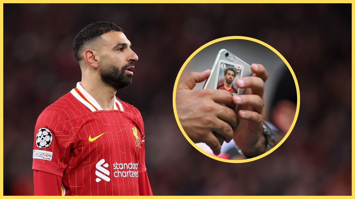 Mo Salah looks at a picture of a pair of hands holding a mobile phone.