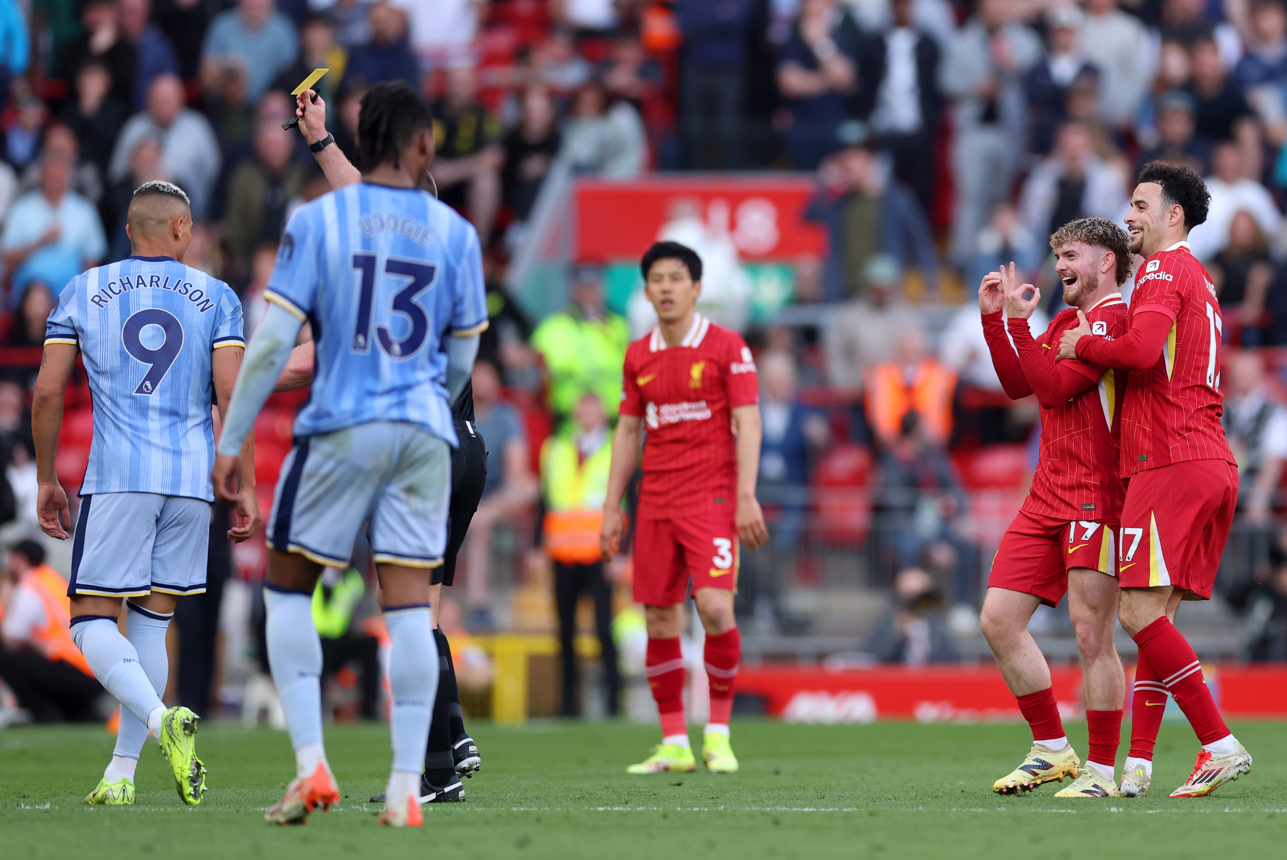 Harvey Elliott laughs as he makes a gesture with his hands at Richarlison.