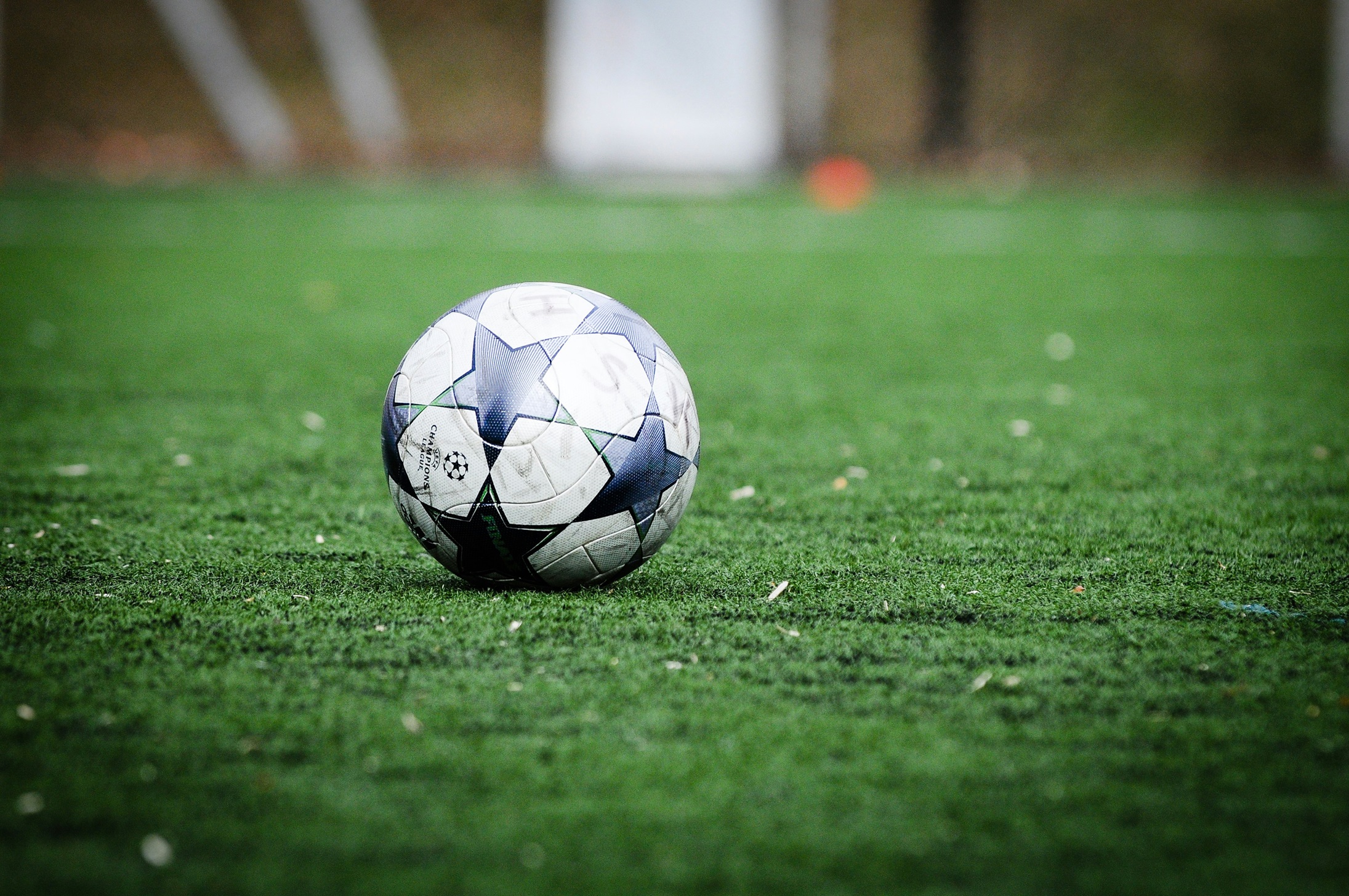Champions League ball rests on the pitch.