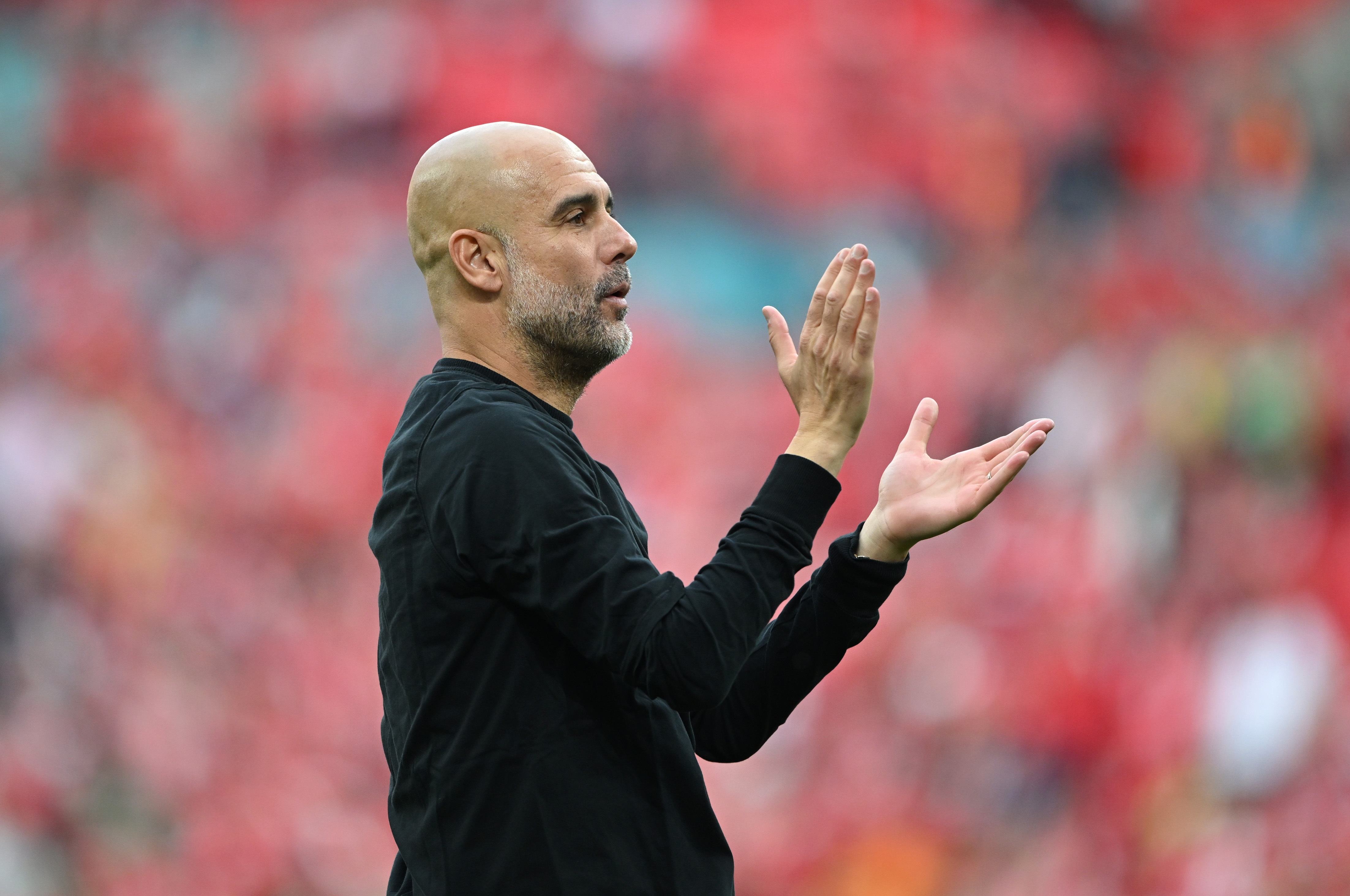 Pep Guardiola claps his hands during Man City game.