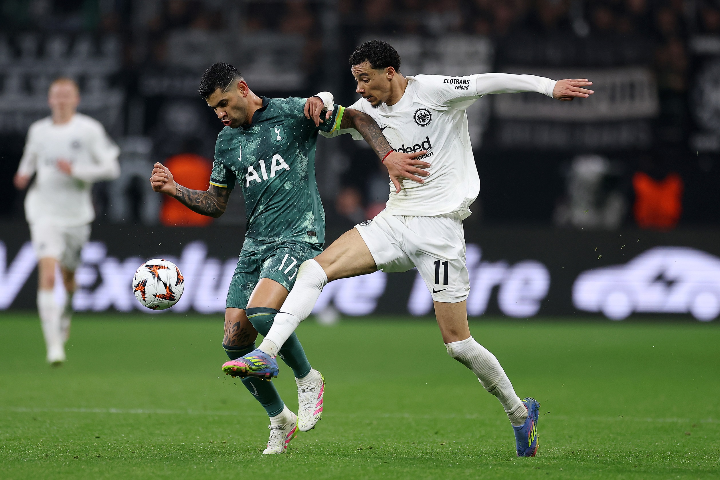 Hugo Ekitike grabs Cristian Romero's shoulder whilst pressuring for the ball.