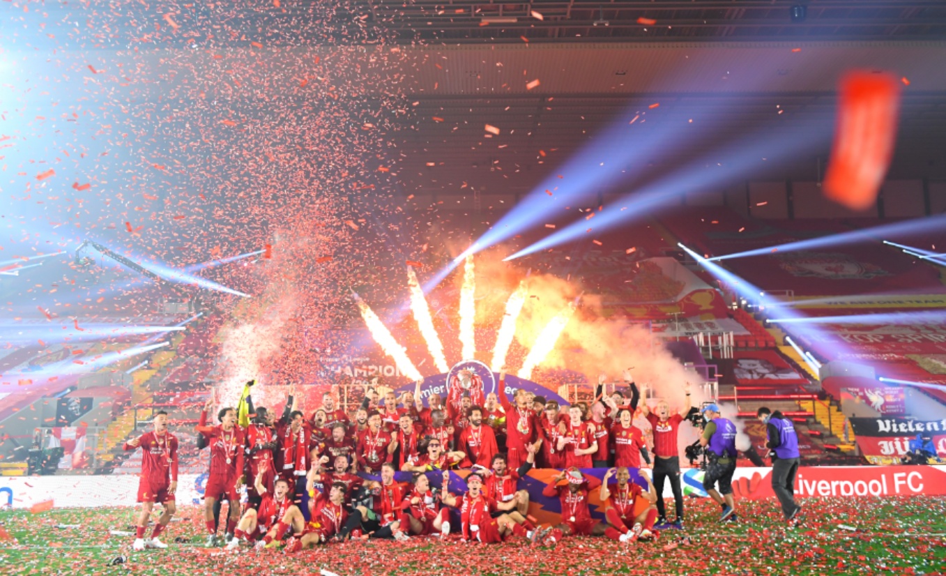 Liverpool players celebrate with the Premier League trophy at an empty Anfield in 2020