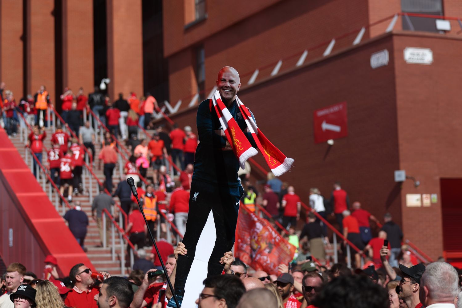 Liverpool supporters celebrating with a cardboard Arne Slot