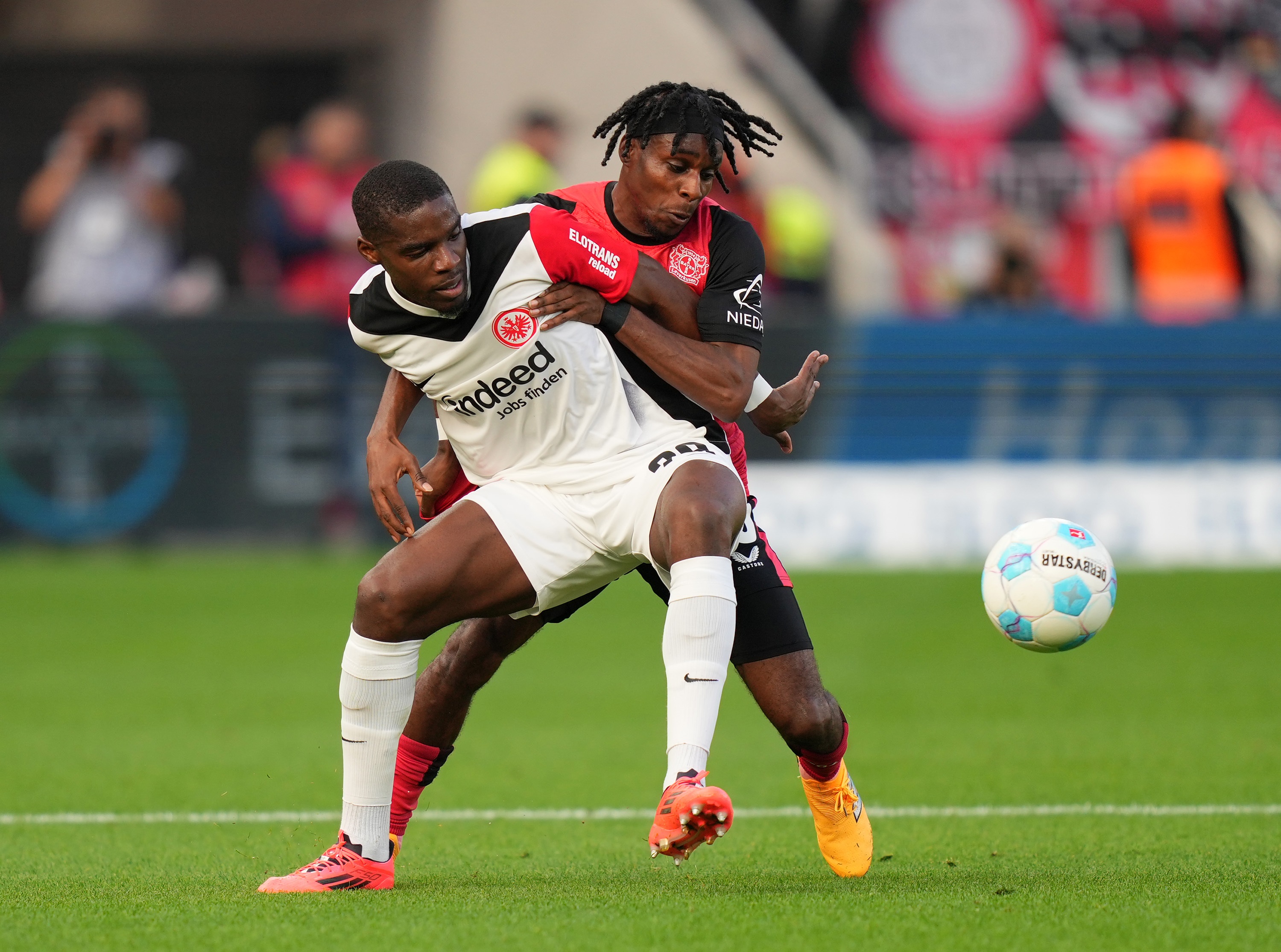 Jeremie Frimpong grapples with Niels Nkounkou on the pitch.