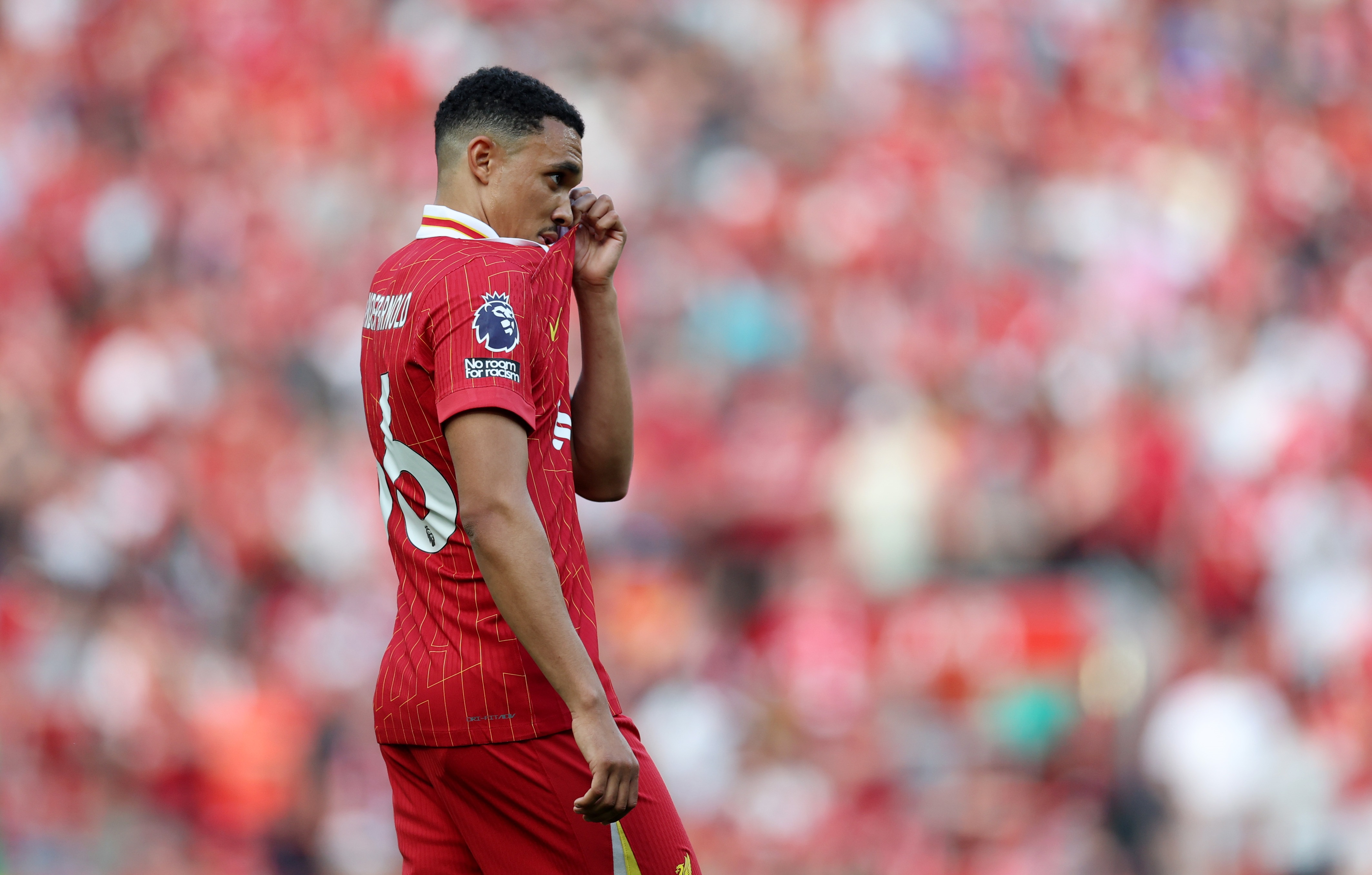 Trent Alexander-Arnold wipes his face with his Liverpool shirt.
