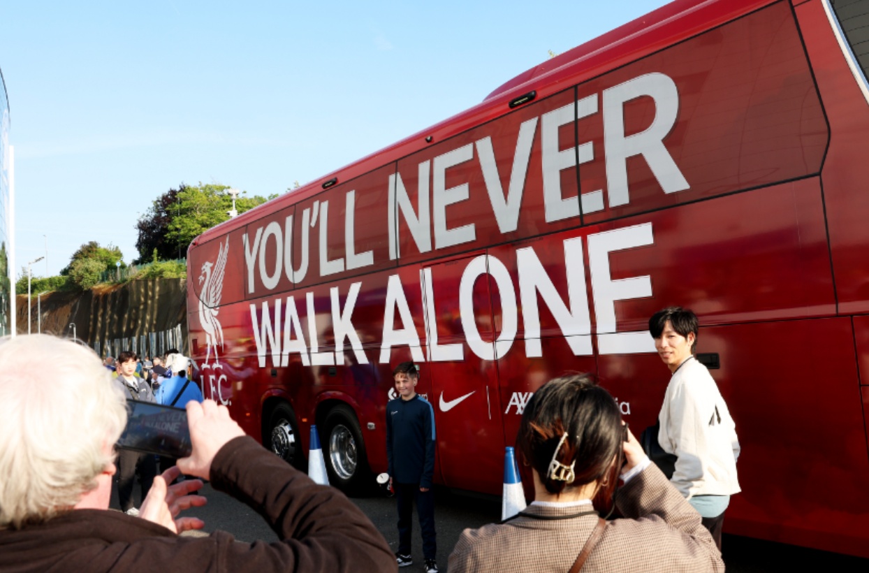 Fans get photos taken next to the Liverpool team bus