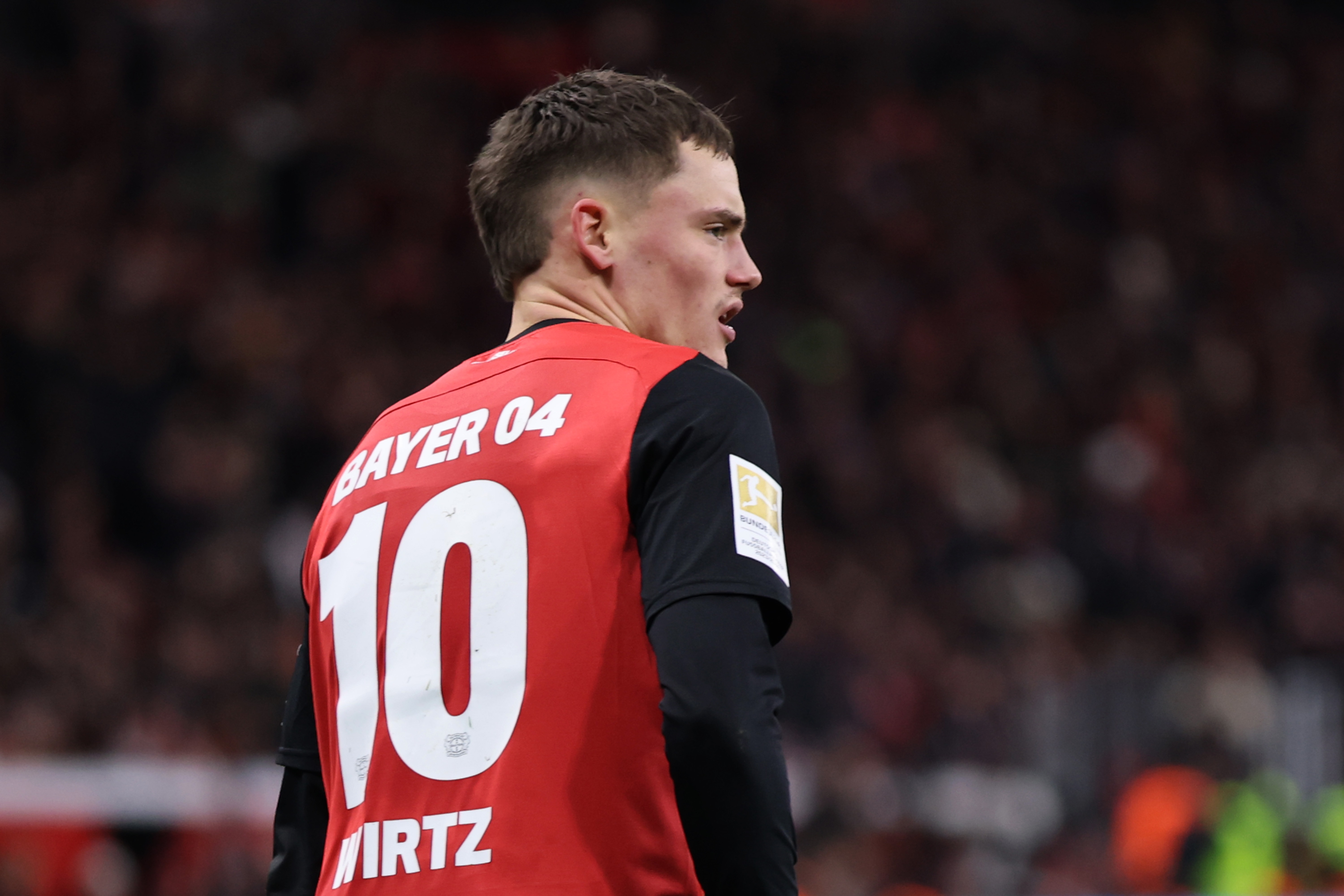 Florian Wirtz looks to his right with his back to the camera.