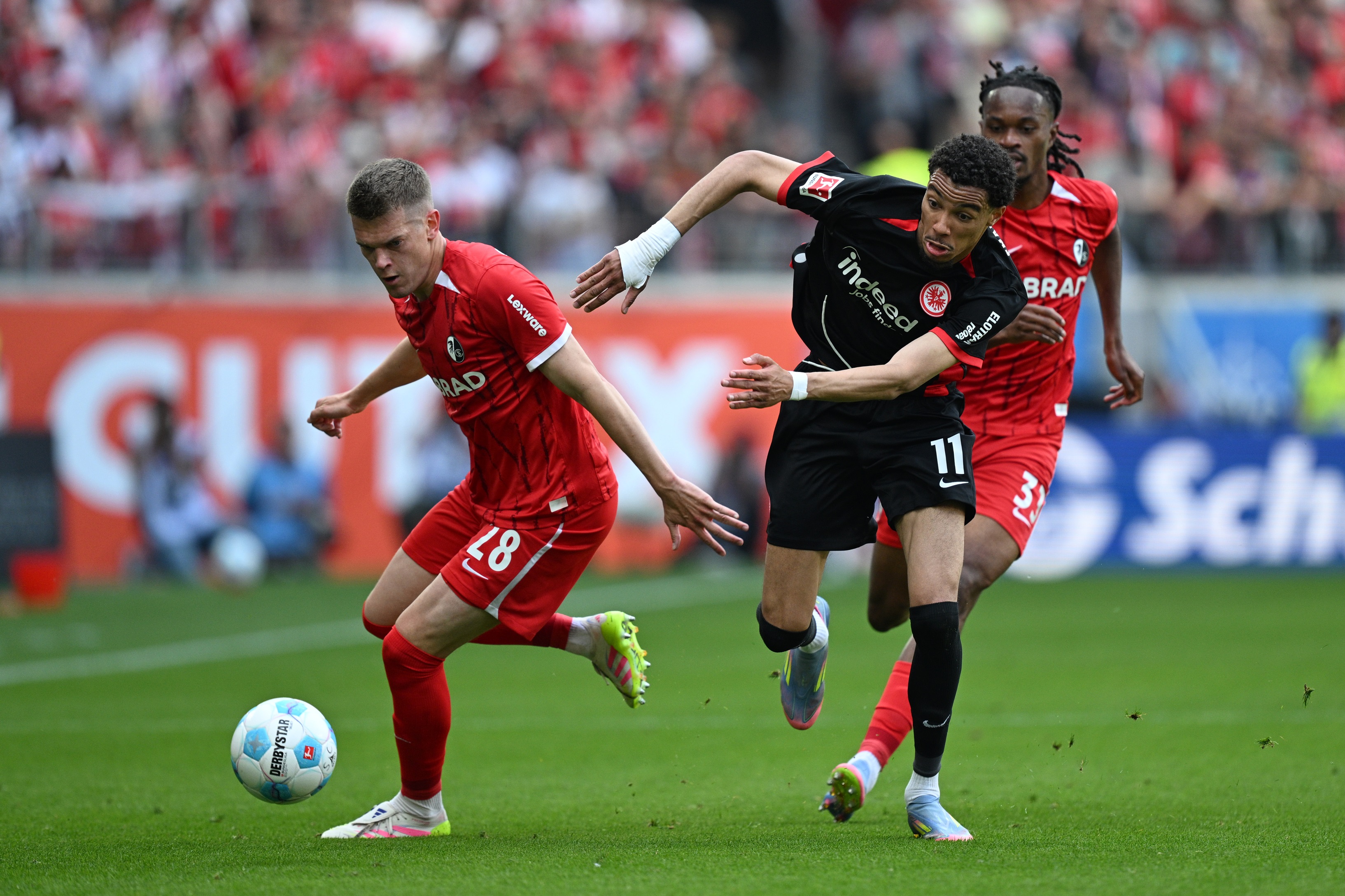Hugo Ekitike chases after Matthias Ginter.