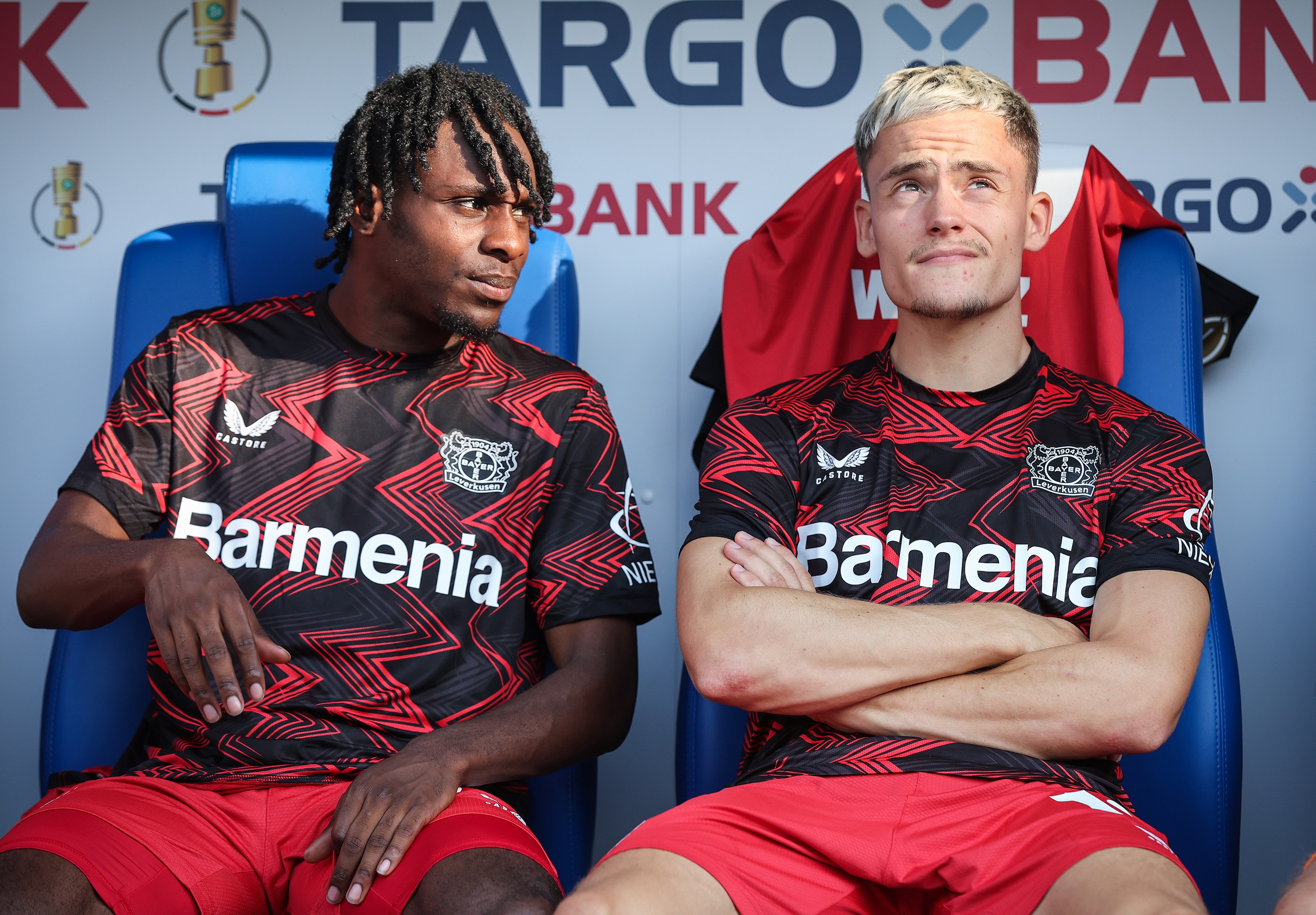 Jeremie Frimpong sits on the bench with Florian Wirtz.