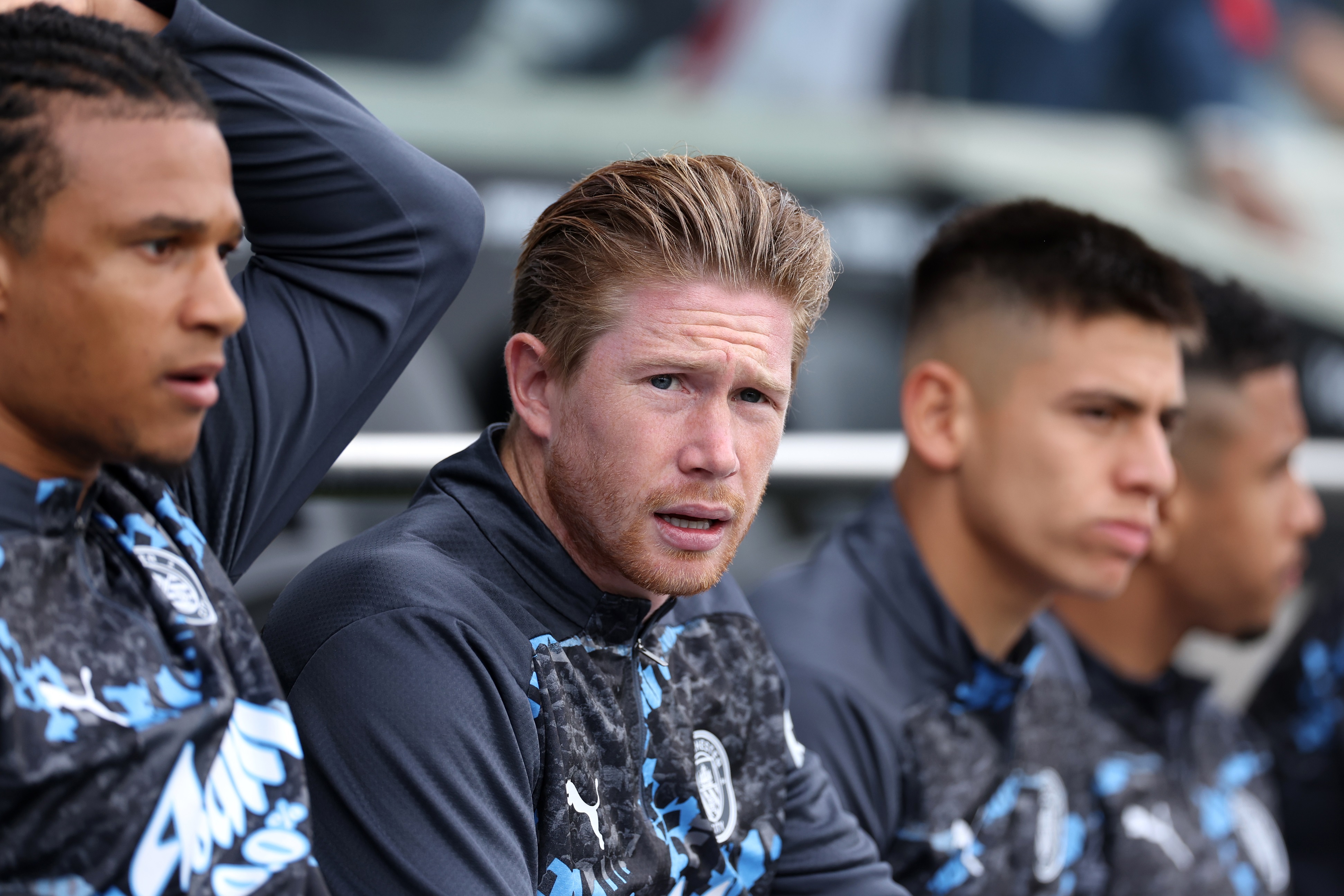 Kevin De Bruyne looks on from Manchester City bench.