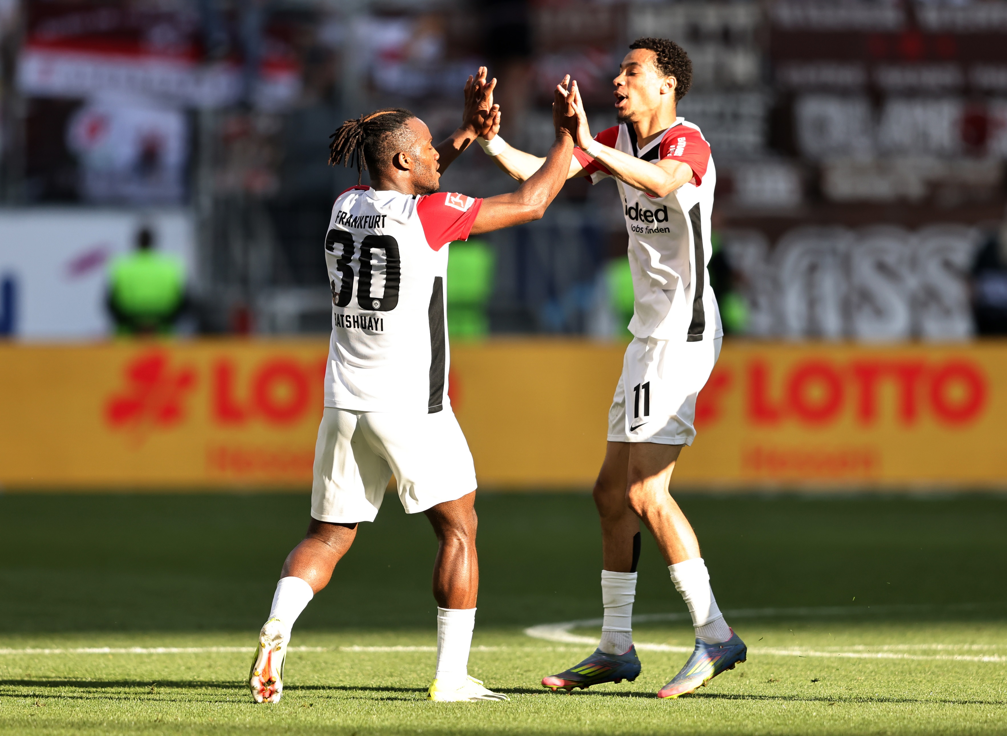 Hugo Ekitike high fives Michy Batshuayi on the pitch.