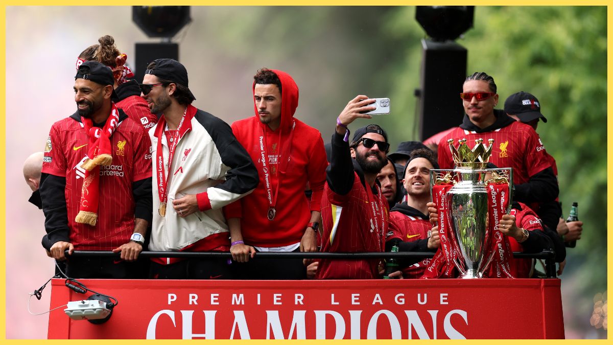 Liverpool players celebrate with Premier League trophy on the open-top bus.