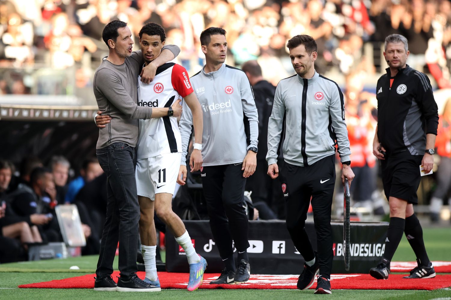 Dino Toppmoller, Head Coach of Eintracht Frankfurt, embraces Hugo Ekitike following substitution during the Bundesliga match for Eintracht Frankfurt