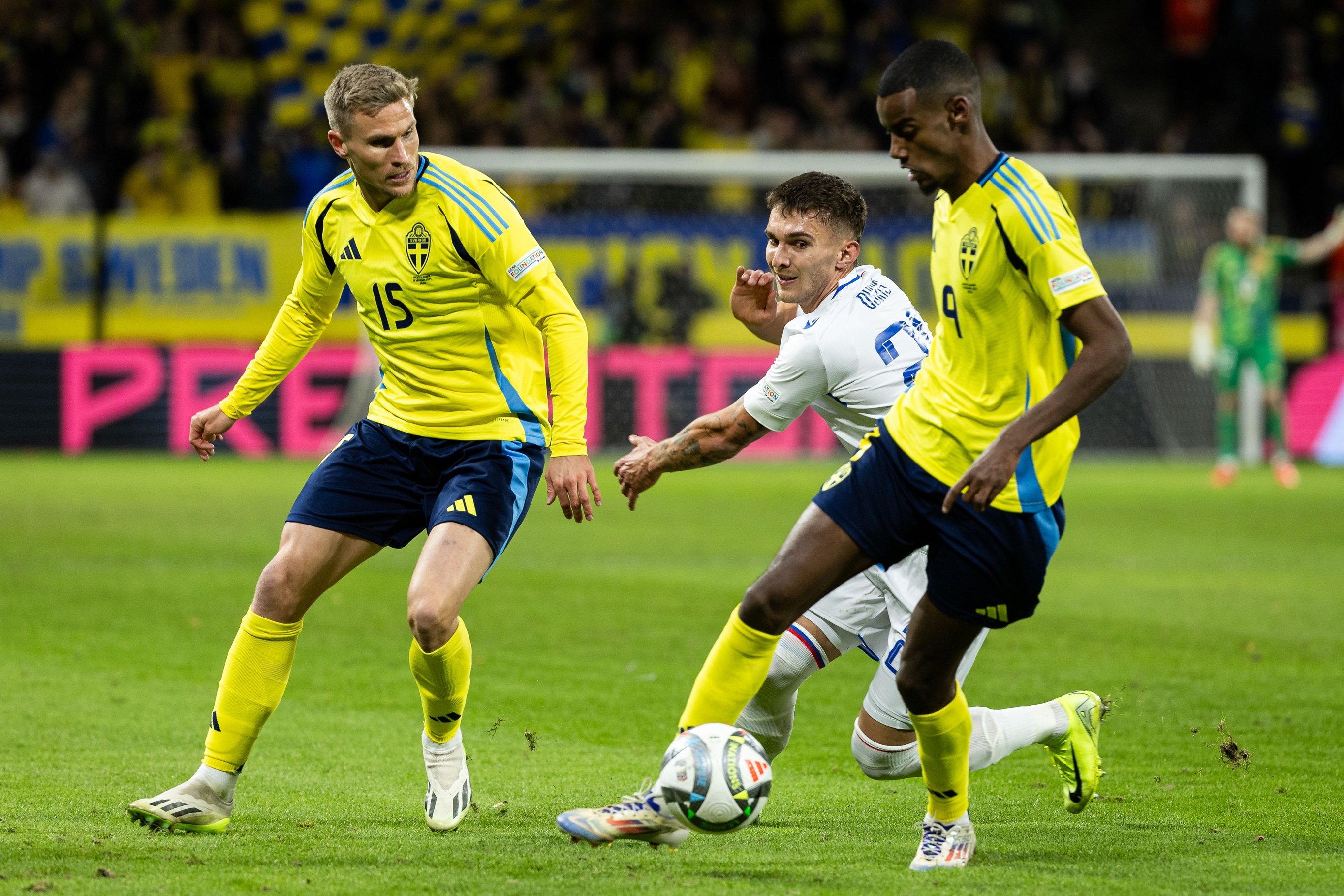 Alexander Isak dribbles with the ball under pressure from Slovakia player.