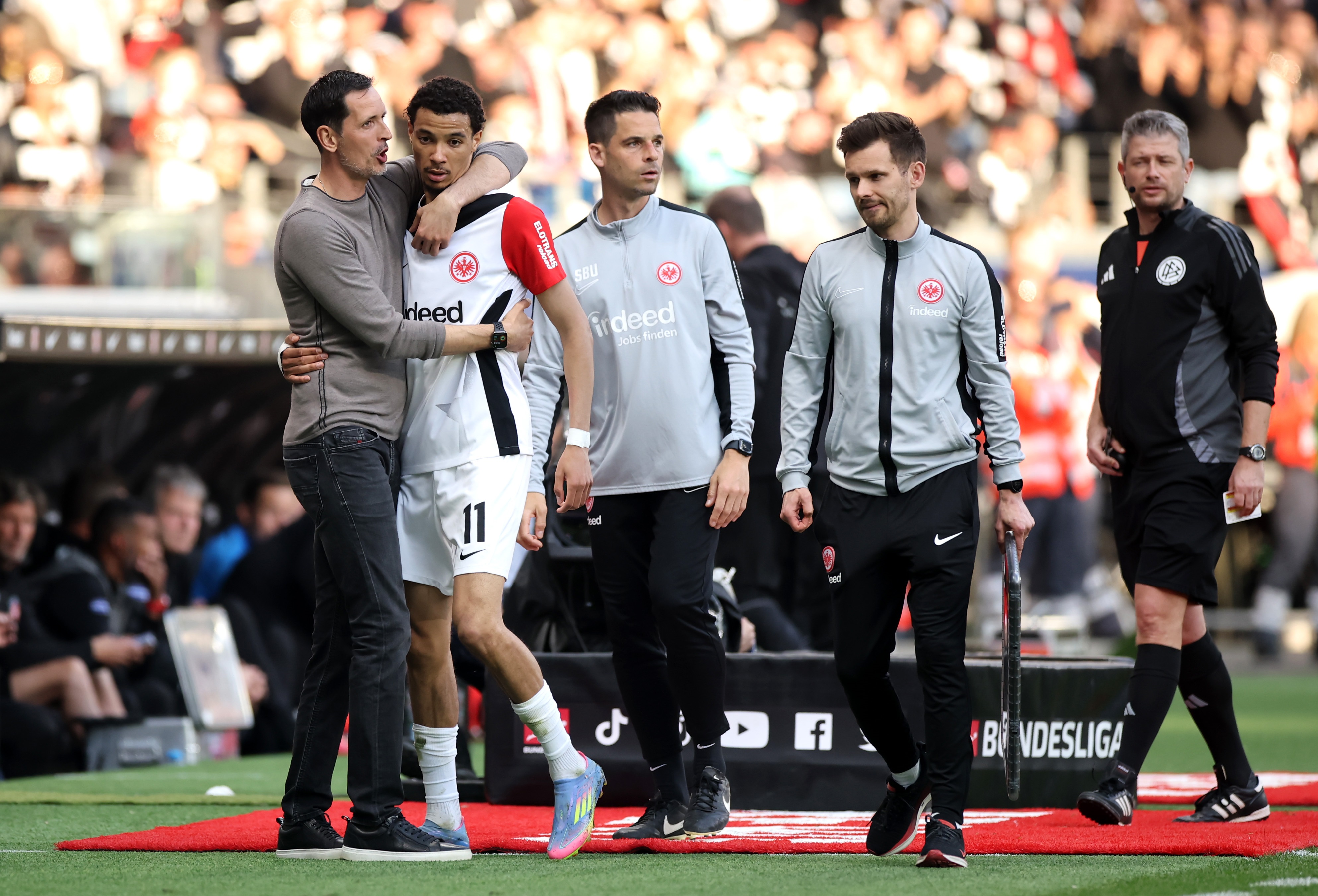 Hugo Ekitike hugs Dino Toppmoller on the sidelines.