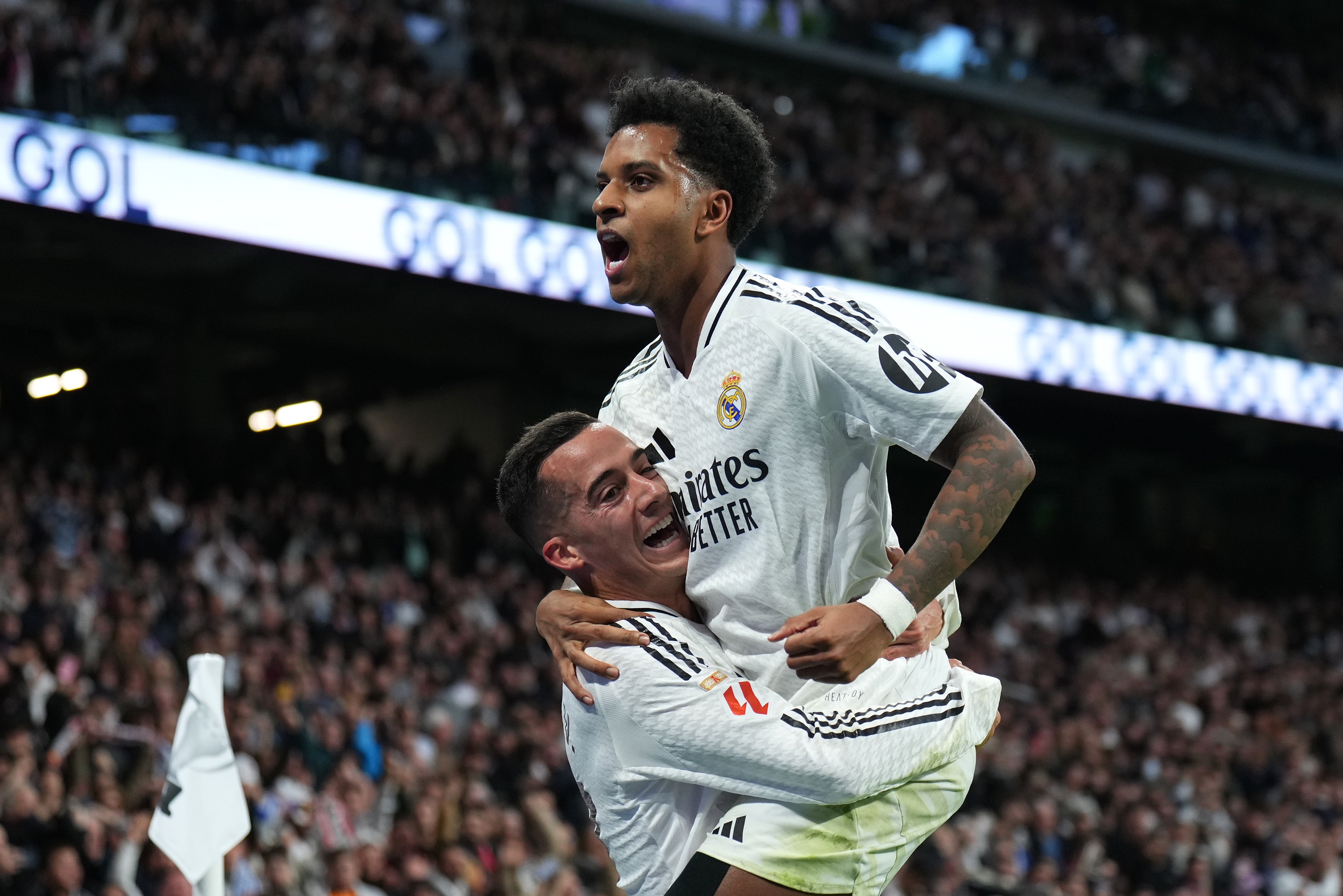 Rodrygo is lifted in the air by Lucas Vazquez.