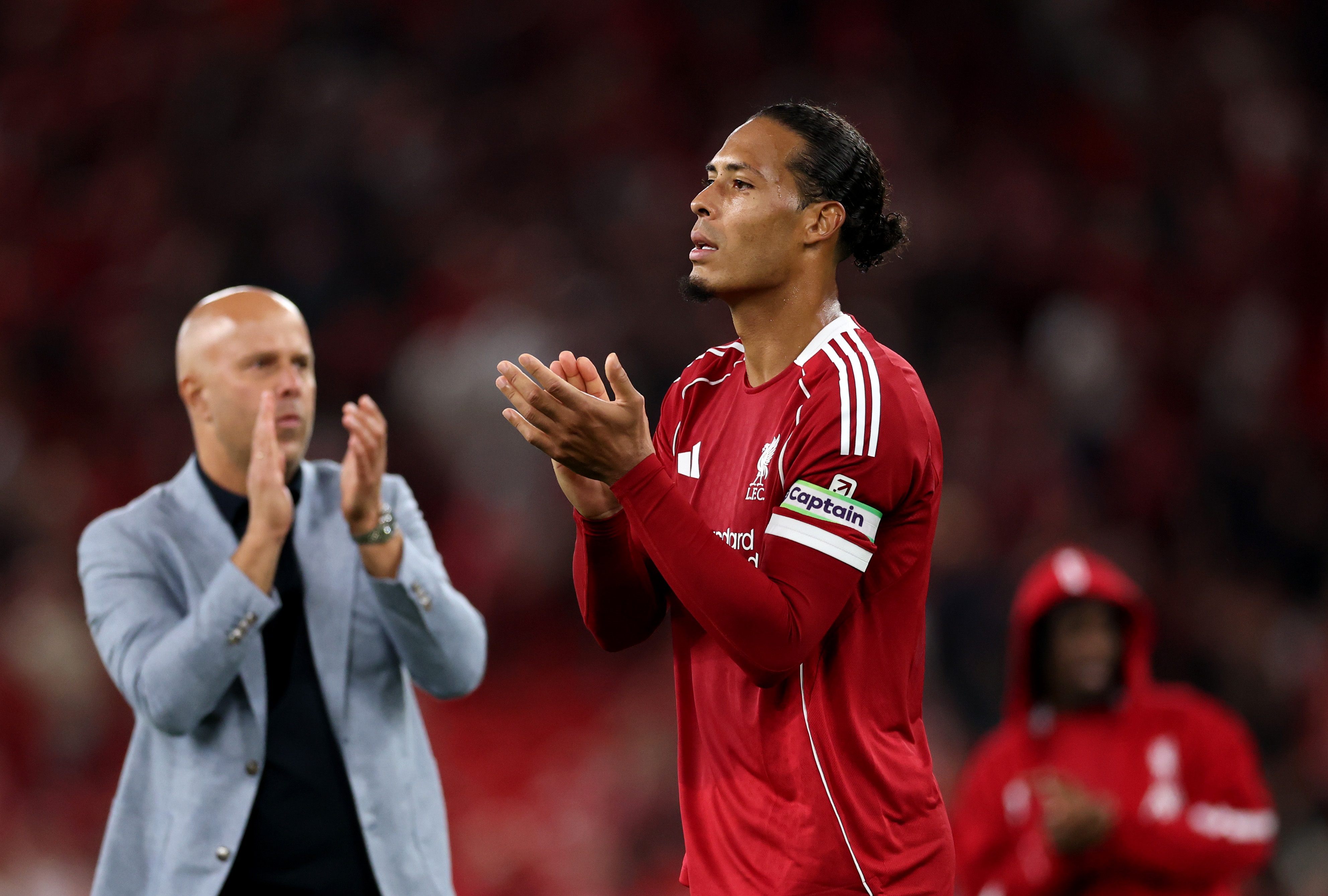 Virgil van Dijk and Liverpool head coach Arne Slot clap their hands.